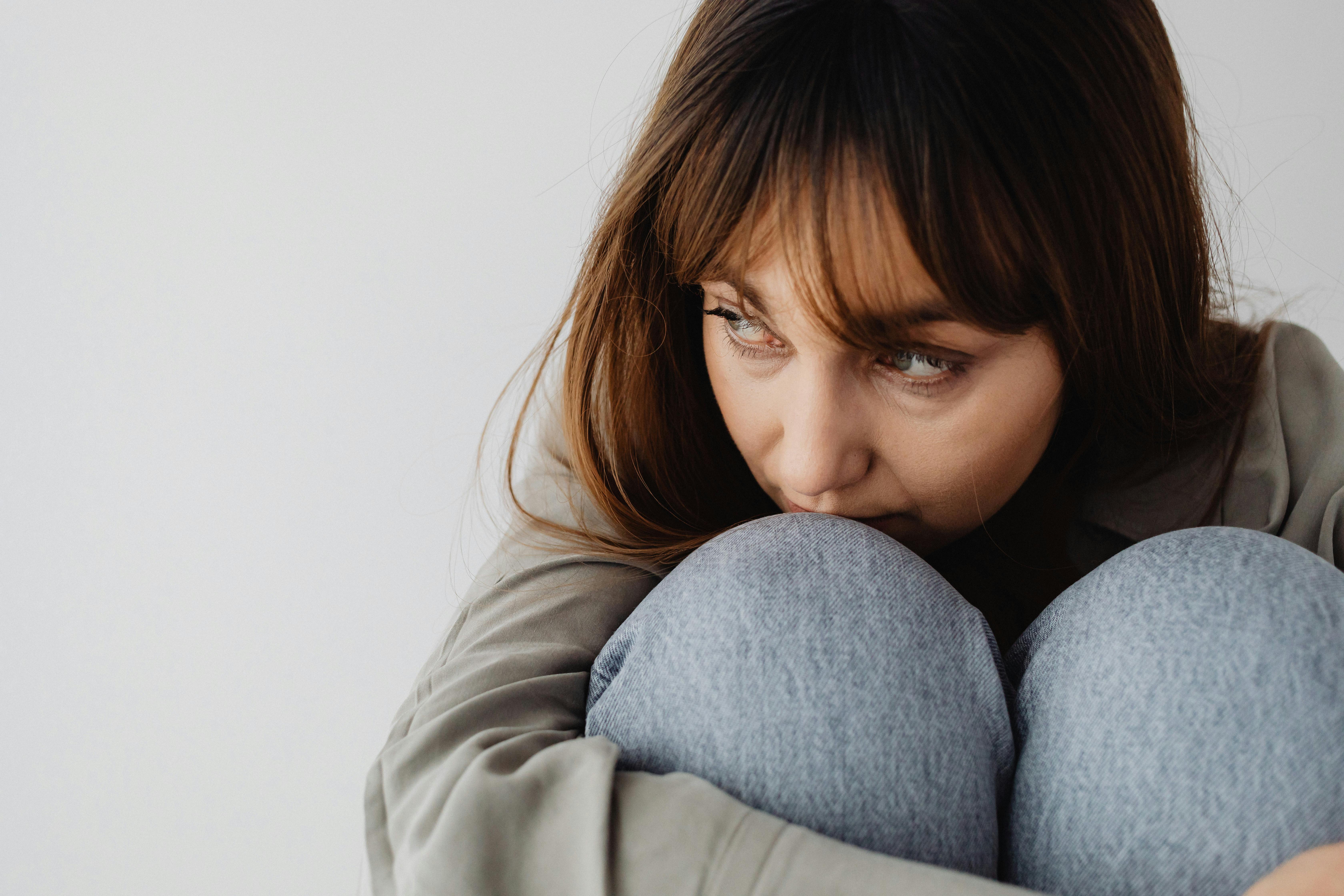 A sad serious woman hugging her knees | Source: Pexels