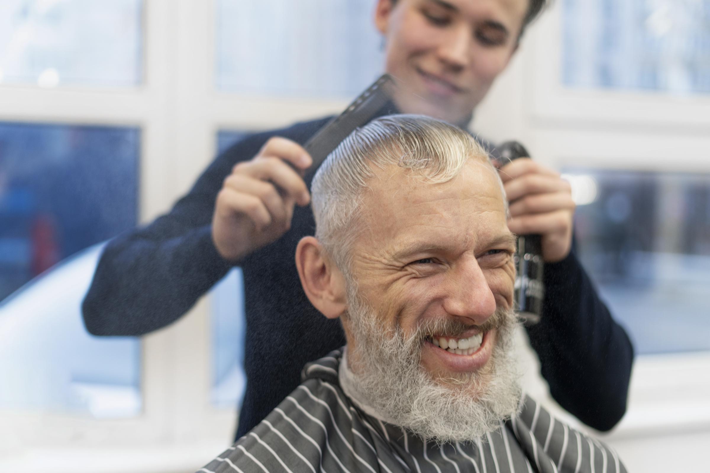 A smiley man at a hair salon | Source: Freepik