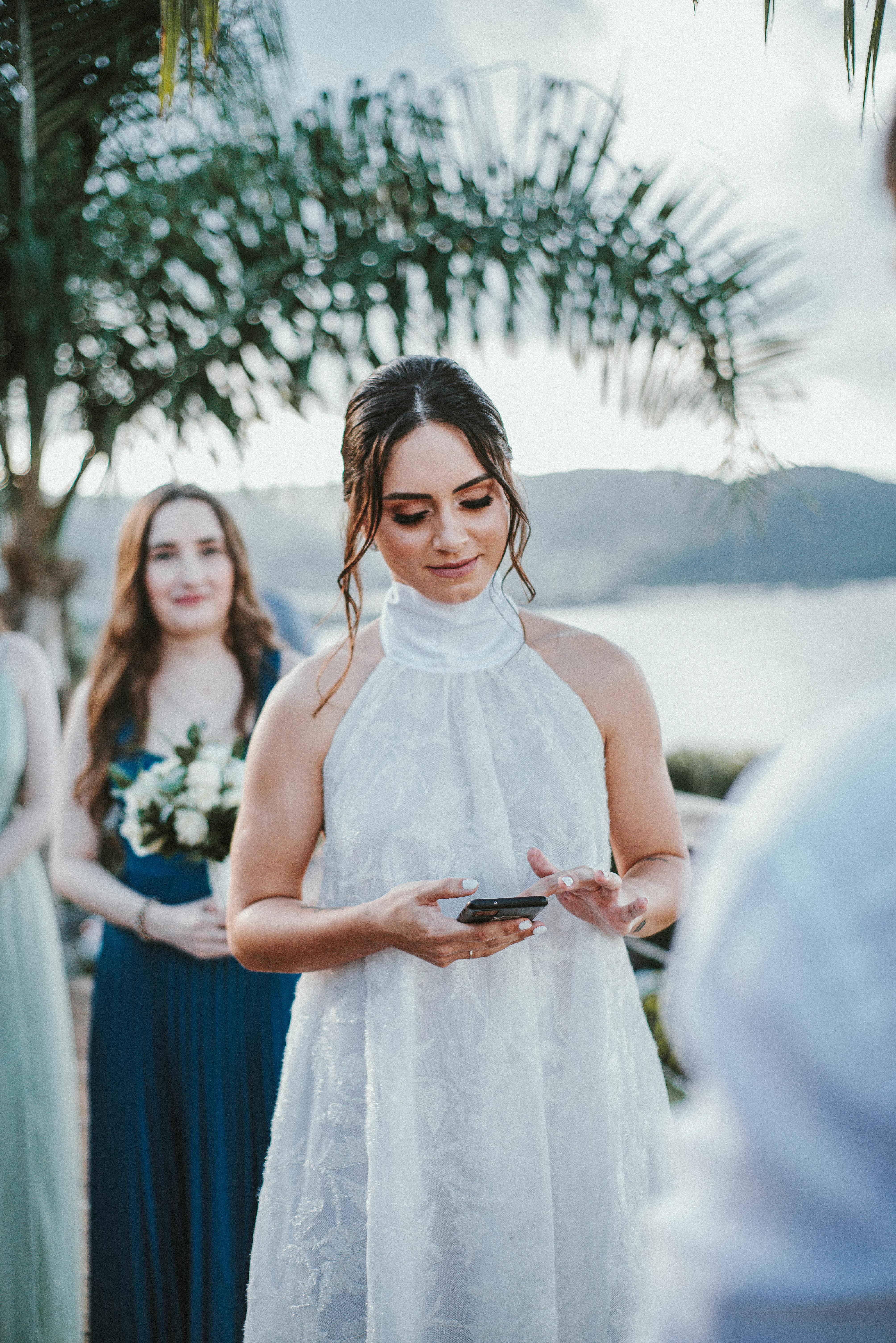 A bride holding a and using phone on her wedding day | Source: Pexels