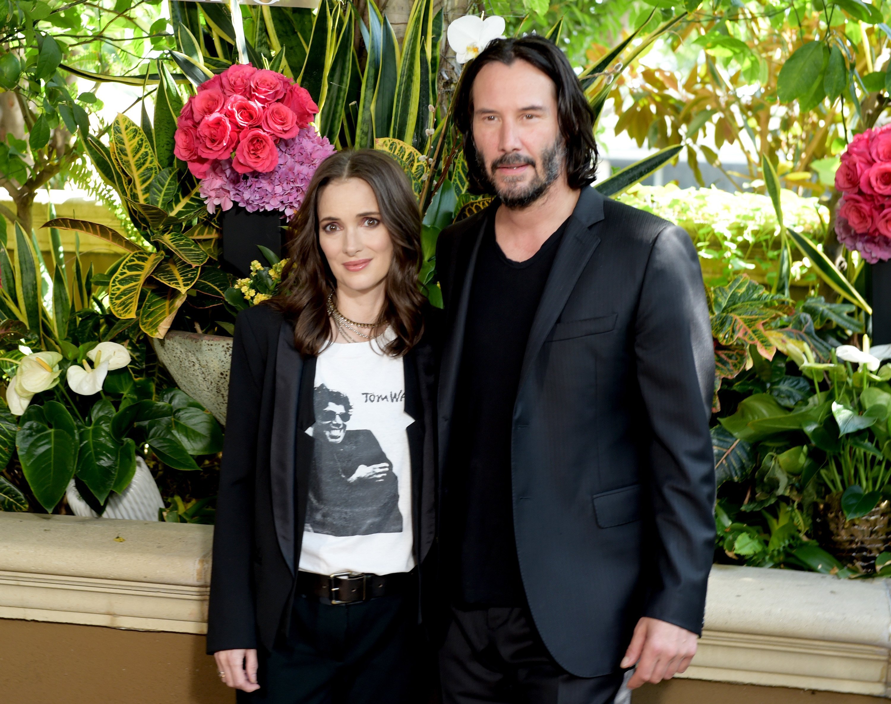 Winona Ryder (L) and Keanu Reeves attend a photo call for Regatta's "Destination Wedding" at the Four Seasons Hotel Los Angeles at Beverly Hills on August 18, 2018, in Los Angeles, California. | Source: Getty Images.