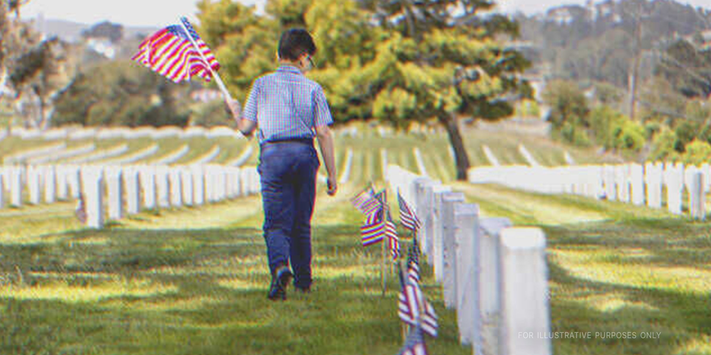 Boy with the U.S. National Flag in a cemetery | Source: Getty Images 