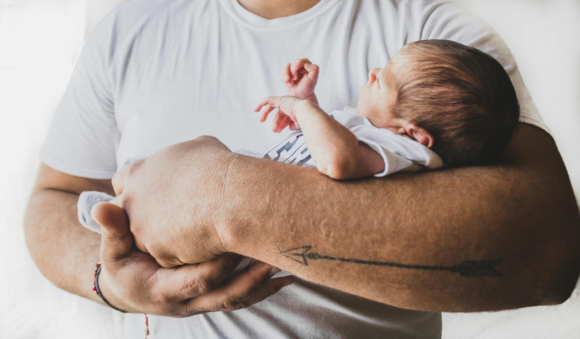 A man holding a newborn baby | Source: Pexels