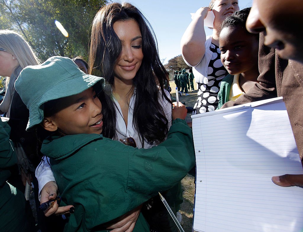 Kim Kardashian signs autographs for school children from the Acacia Primary School during a vist to the Acacia Primary school in Botswana , July 2009 | Source: Getty Images