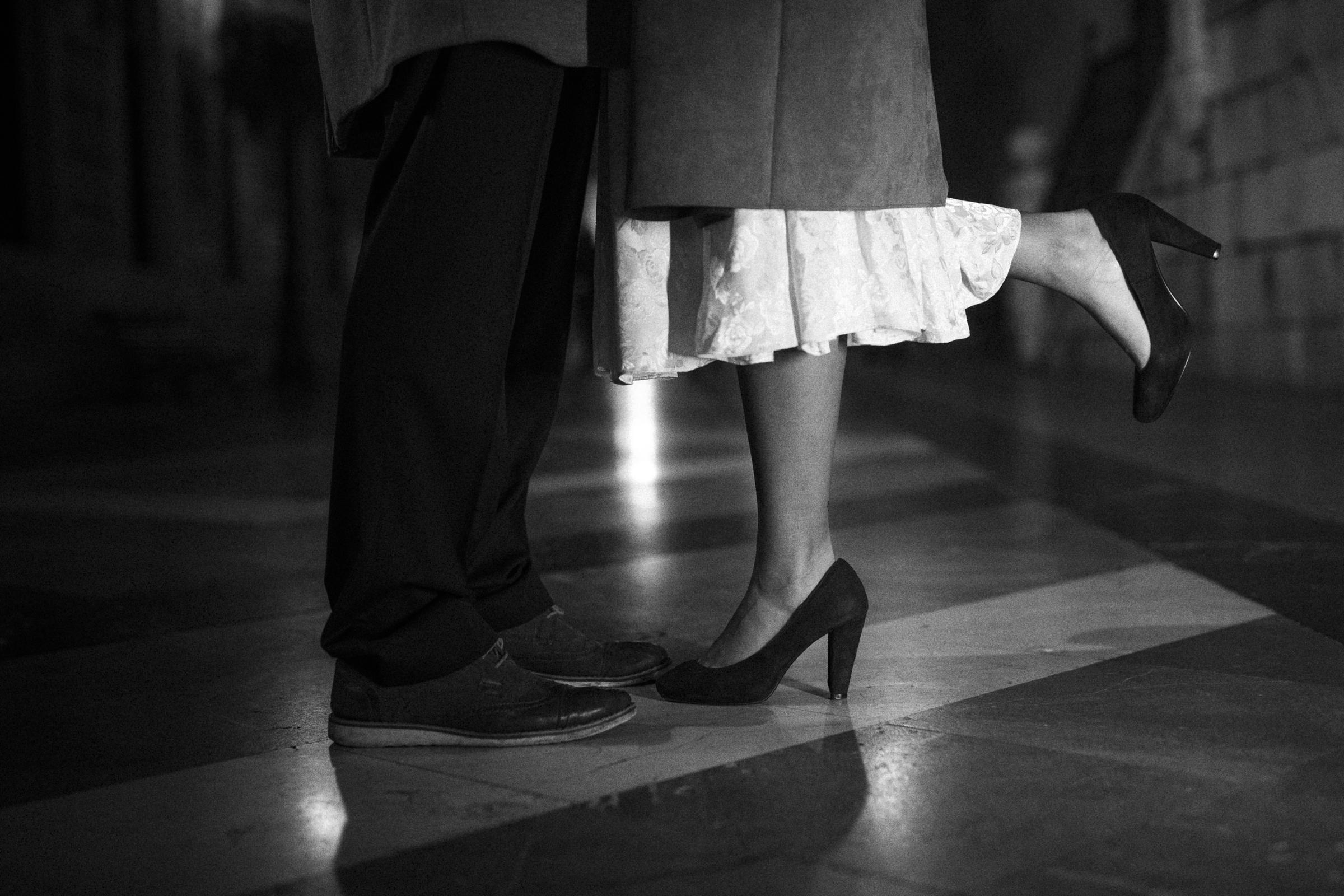 Grayscale cropped image of couple showing their shoes | Source: Freepik