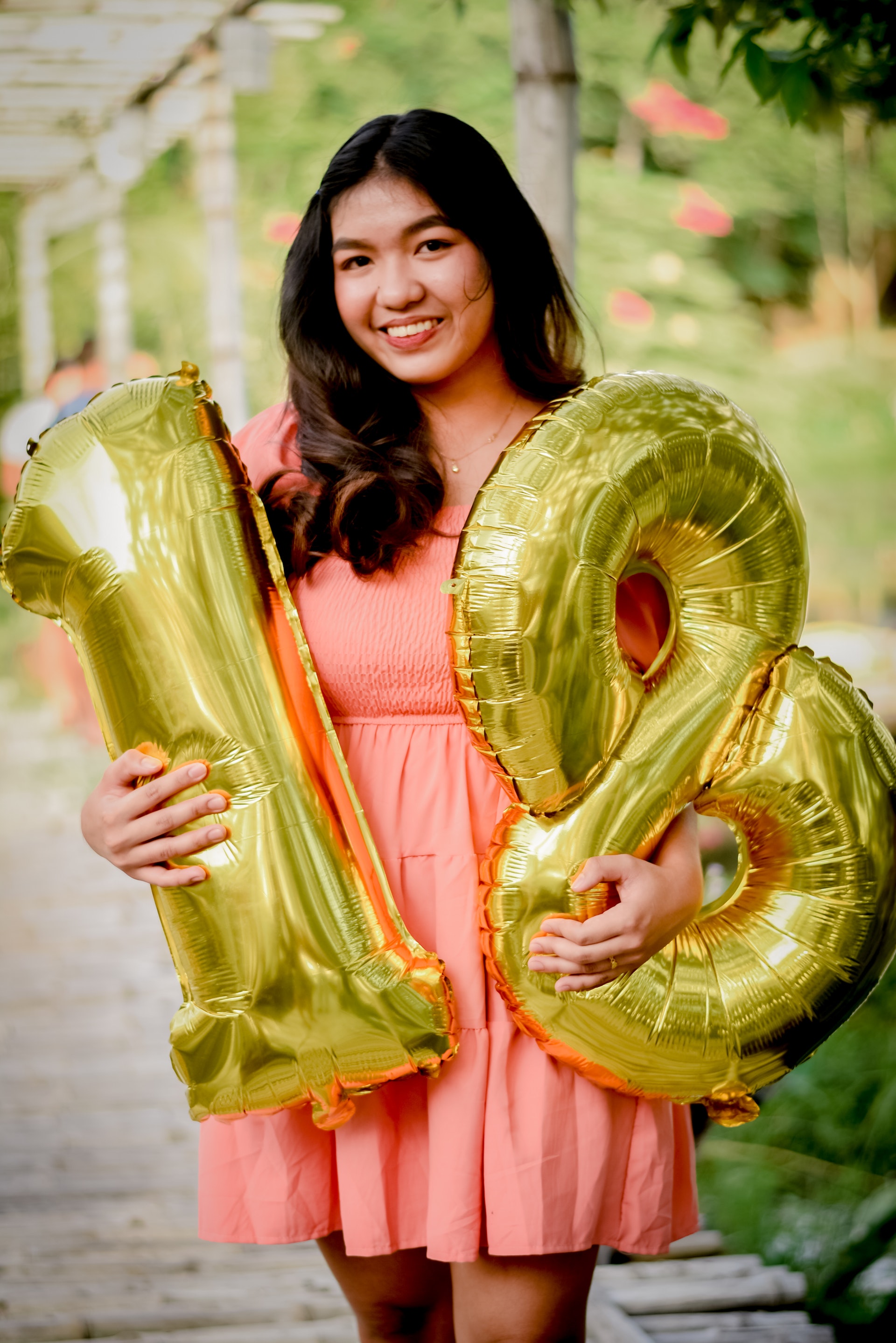 A young girl poses with balloons on her 18th birthday | Source: Pexels