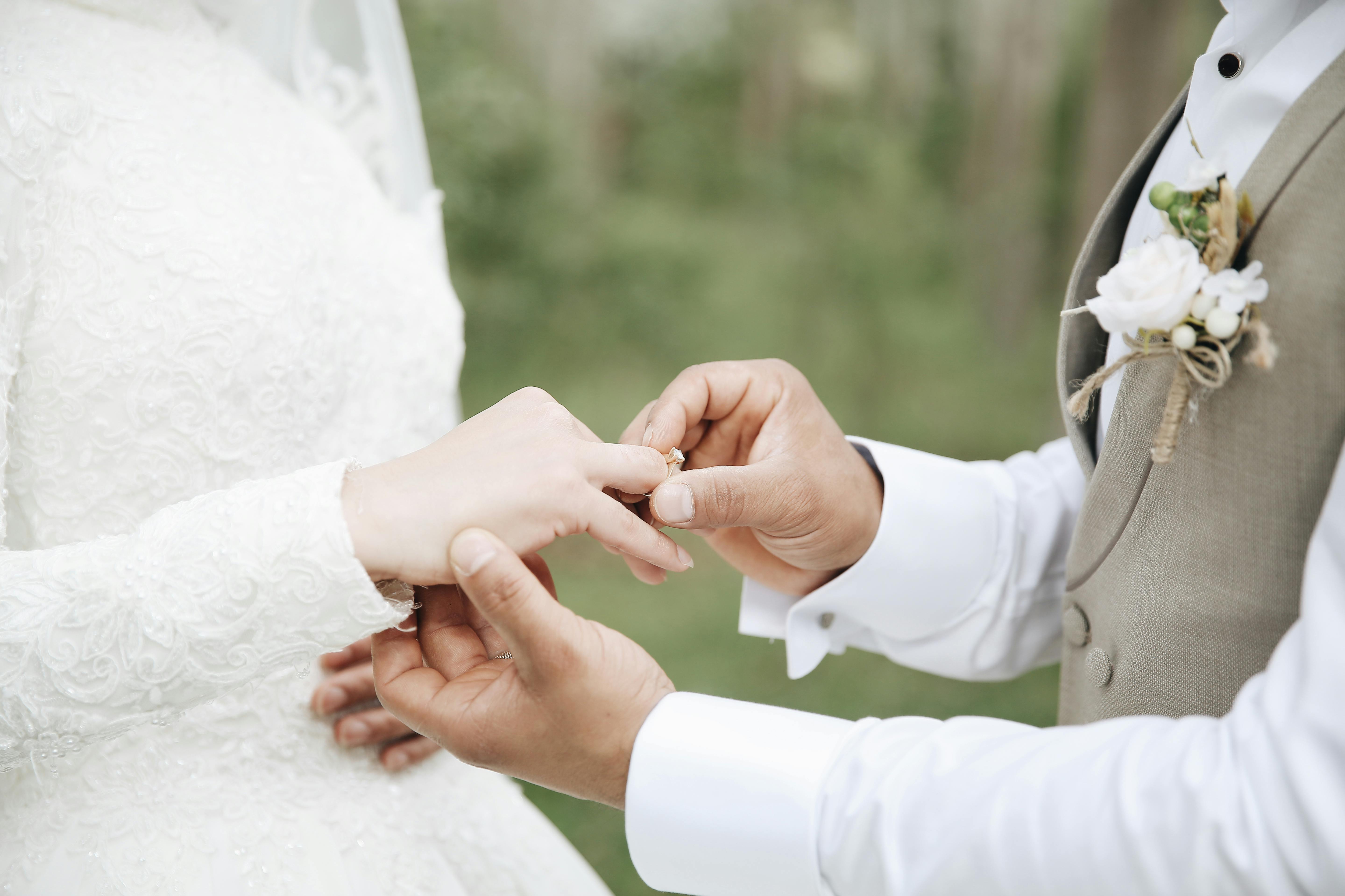 A man placing a wedding ring on a woman's finger | Source: Pexels