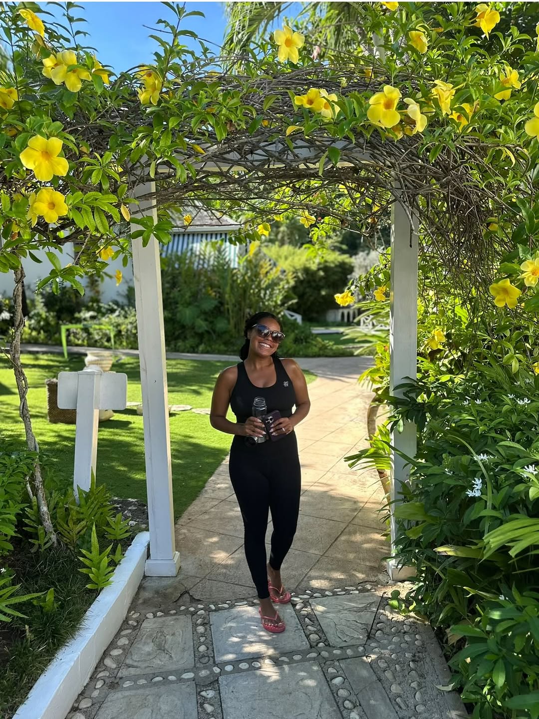 Sheinelle Jones stands outdoors beneath a charming garden archway, from a post dated September 22, 2025. | Source: Instagram/sheinelle_o