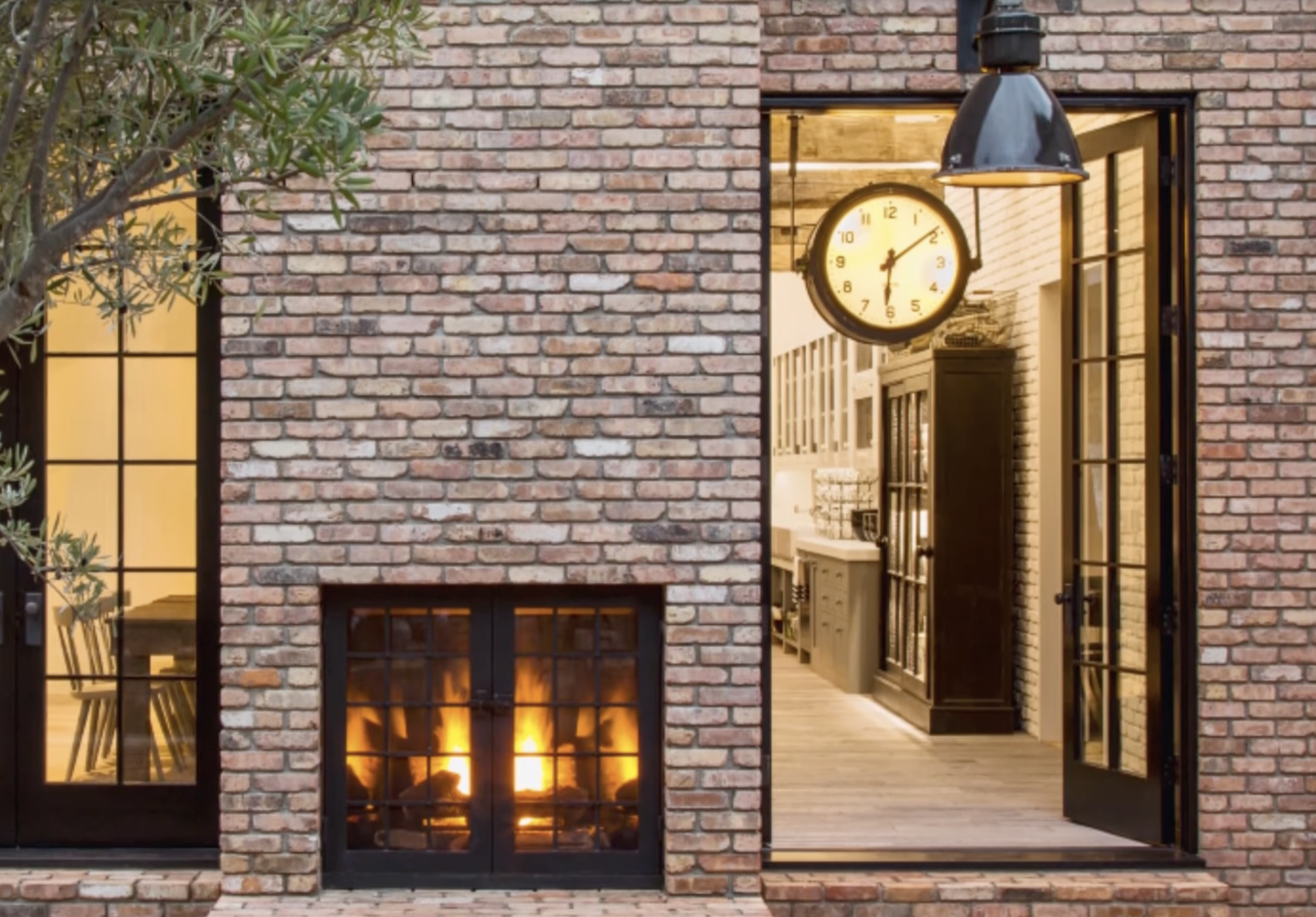 Exterior view into the kitchen and living area of Diane Keaton’s Sullivan Canyon home, featuring a lit fireplace and vintage clock, dated February 3, 2022 | Source: YouTube/@FamousEntertainment500k