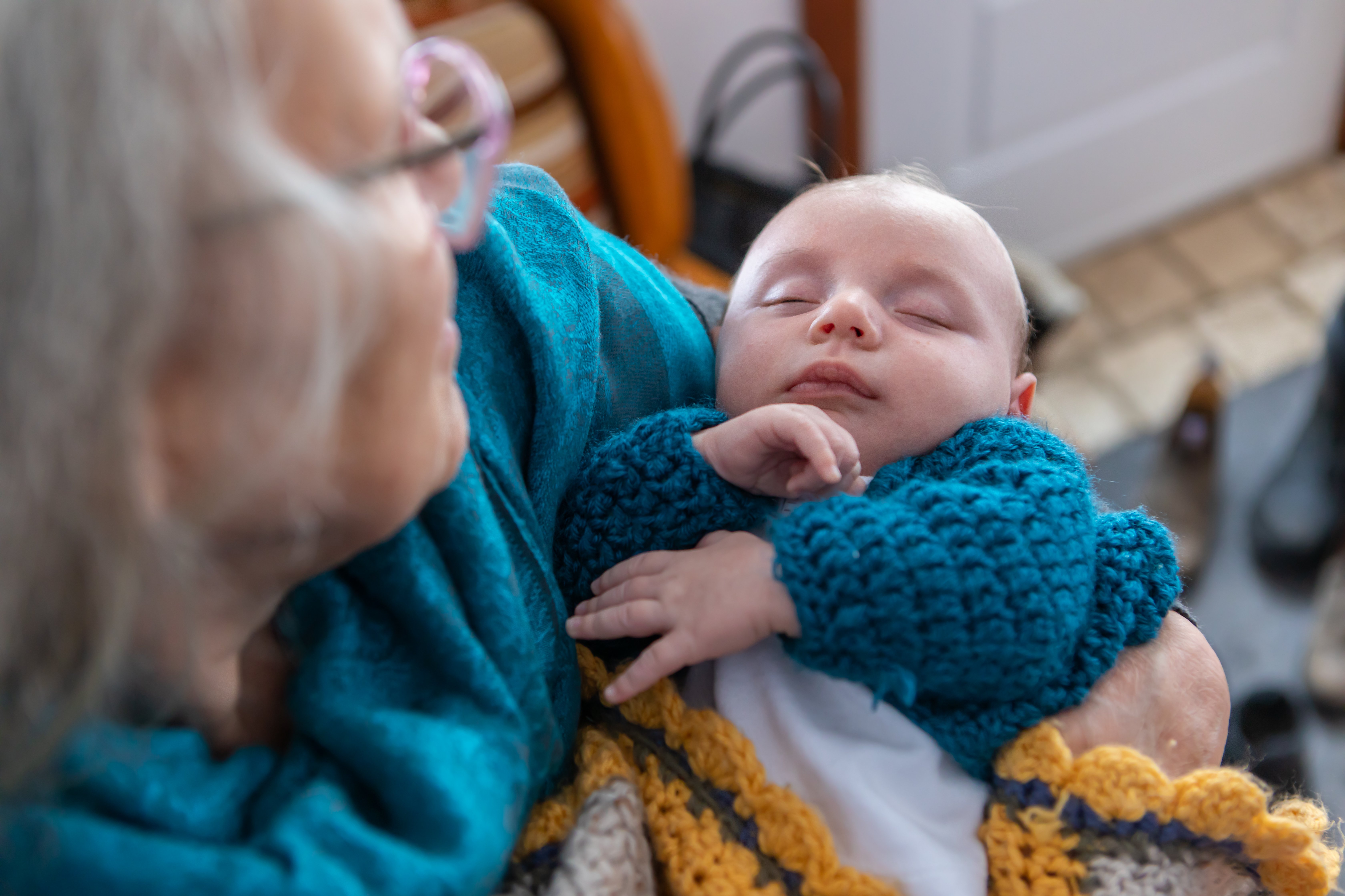 Ältere Frau hält ein Baby. | Quelle: Shutterstock