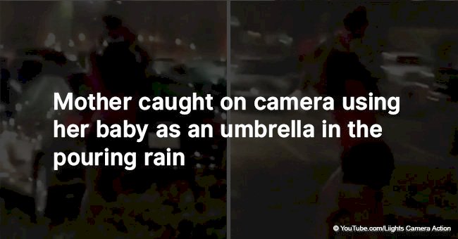 Mother caught on camera using her baby as an umbrella in the pouring rain 