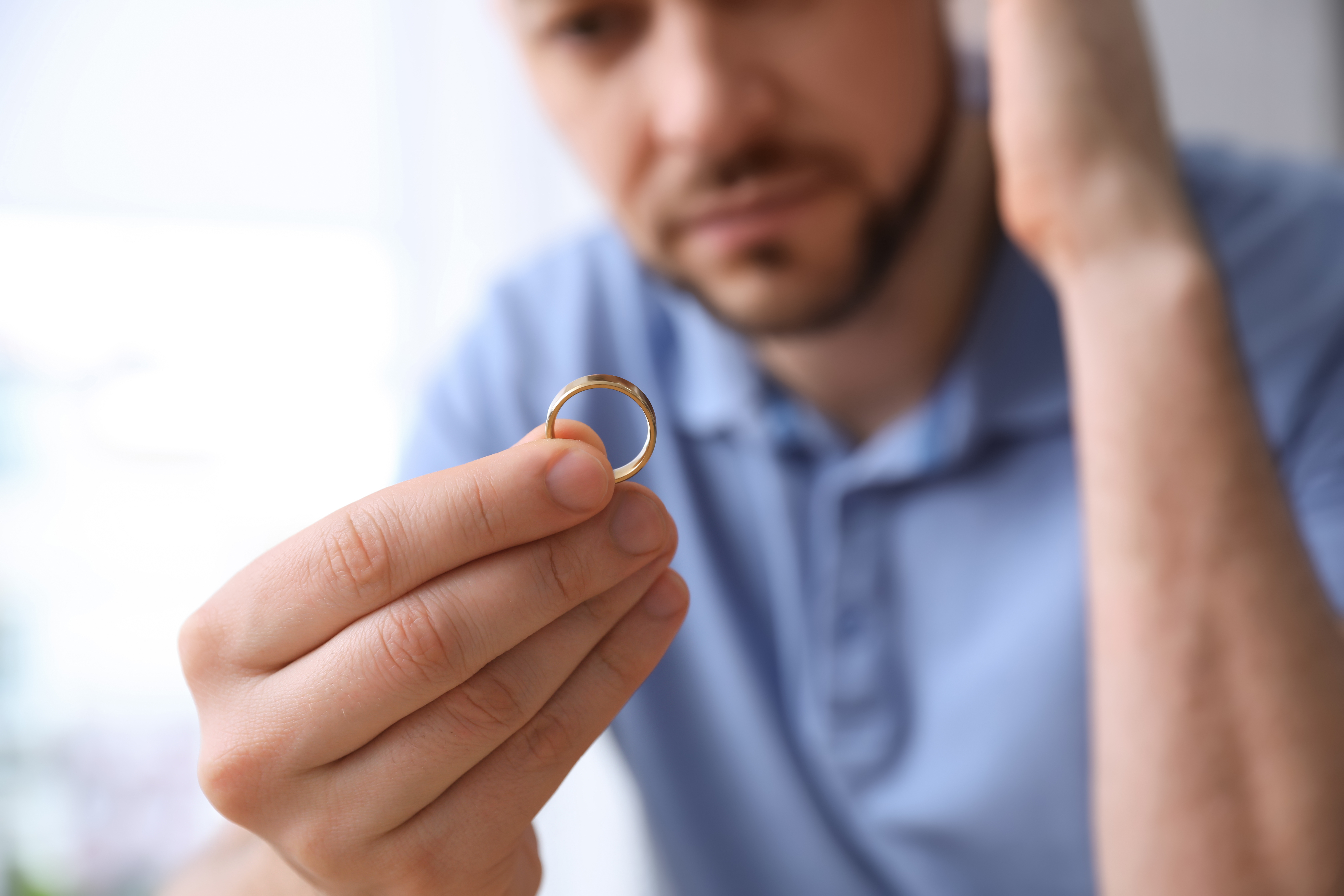 A frustrated man holding a ring | Source: Shutterstock