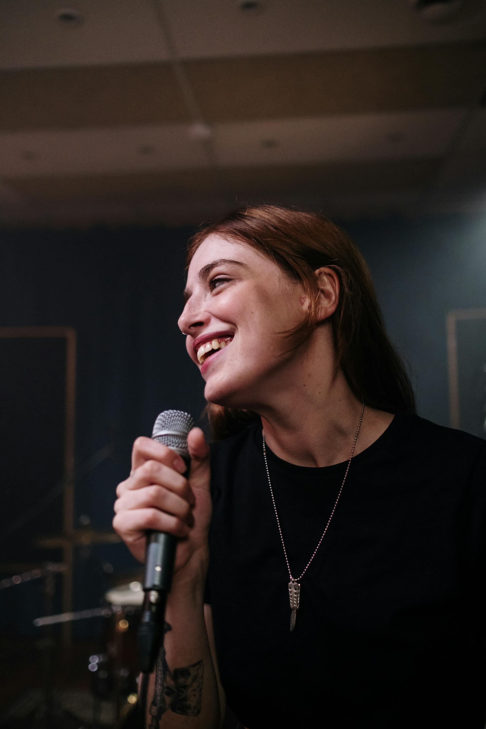 Woman speaking into a microphone | Source: Pexels