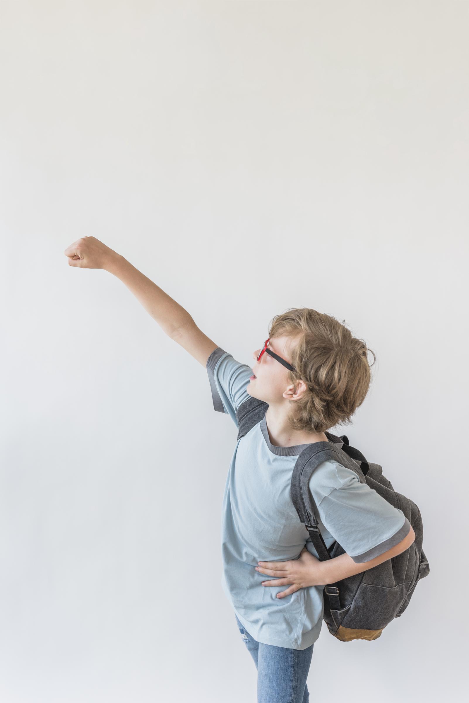 Side view of a young boy with his backpack | Source: Freepik