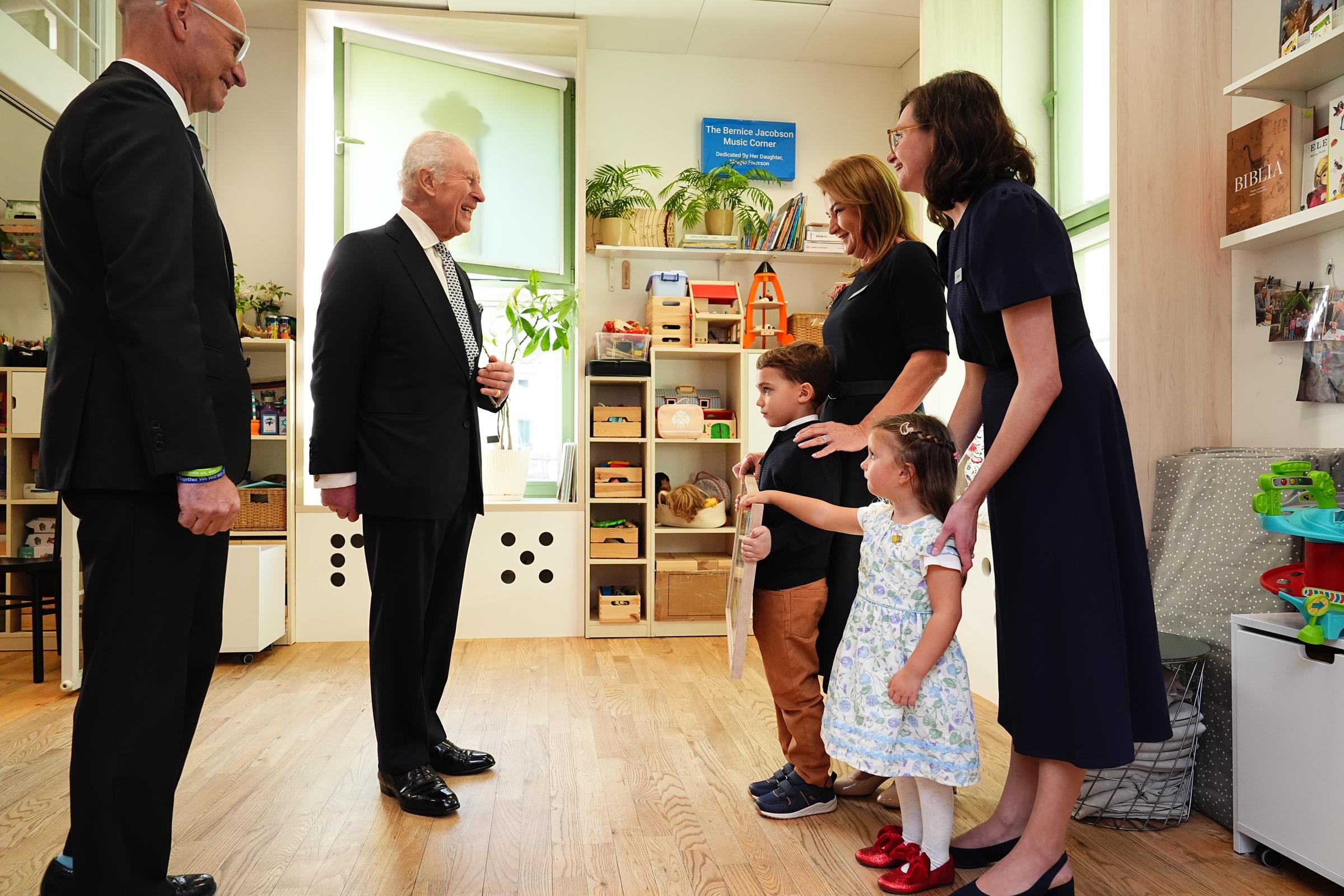 King Charles III is presented with a painting from children thanking him for his visit to the Jewish Community Centre | Source: Getty Images