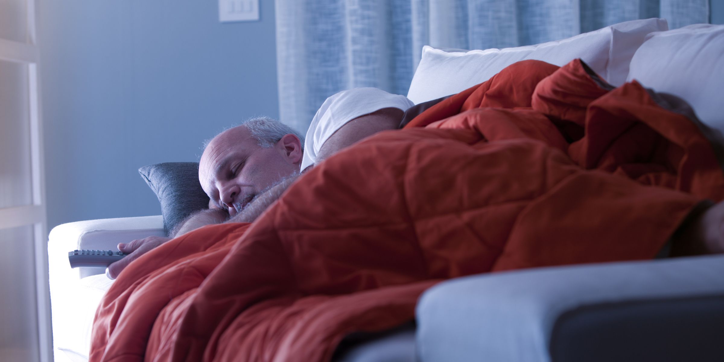 A man sleeping on a couch | Source: Shutterstock