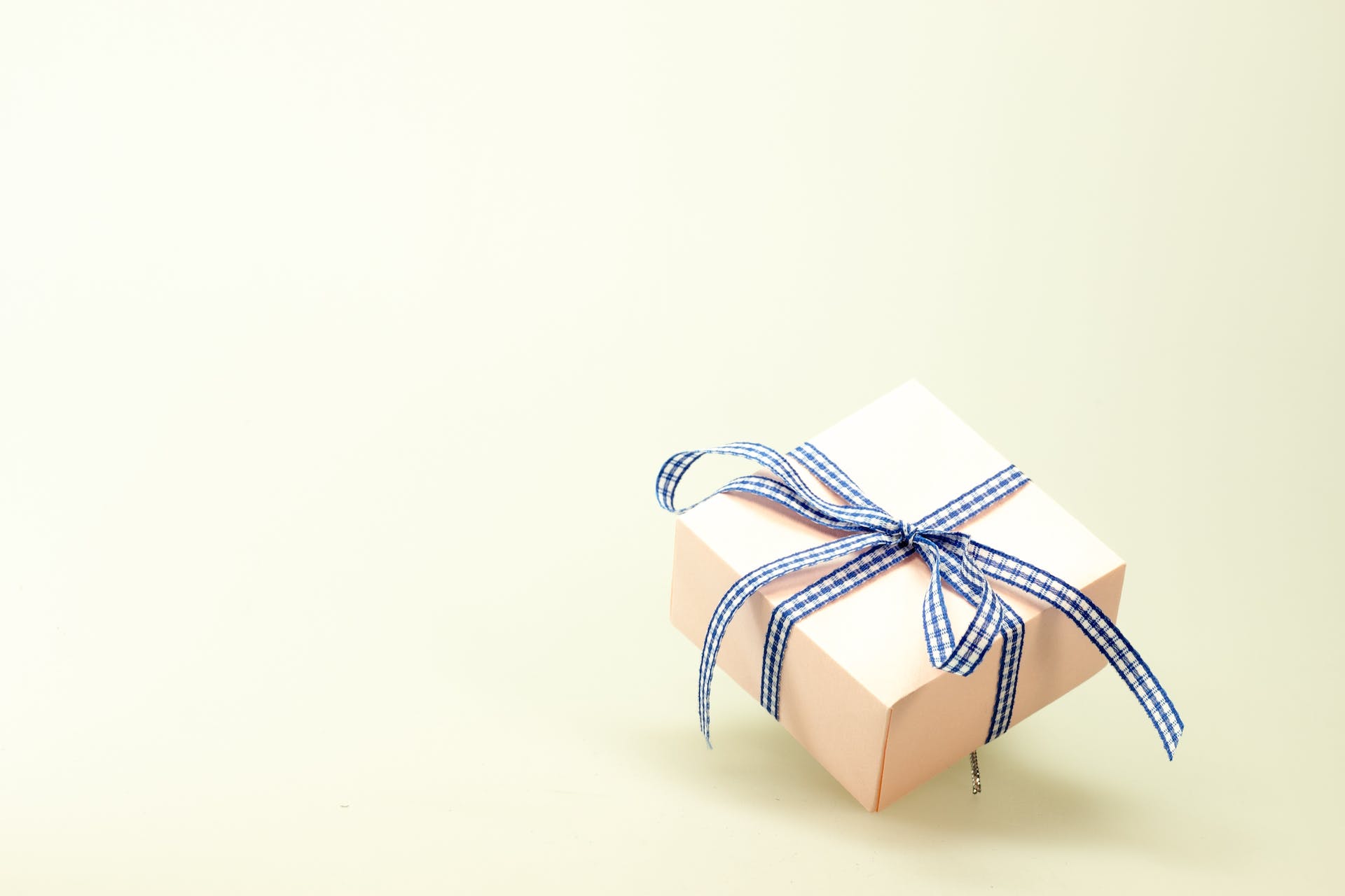 White gift box with blue ribbon. | Source: Pexels