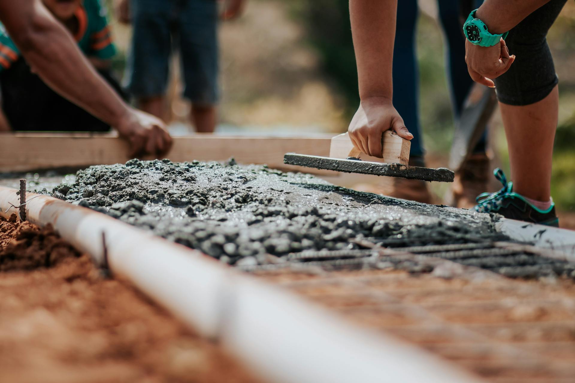 Close-up of people working with cement | Source: Pexels