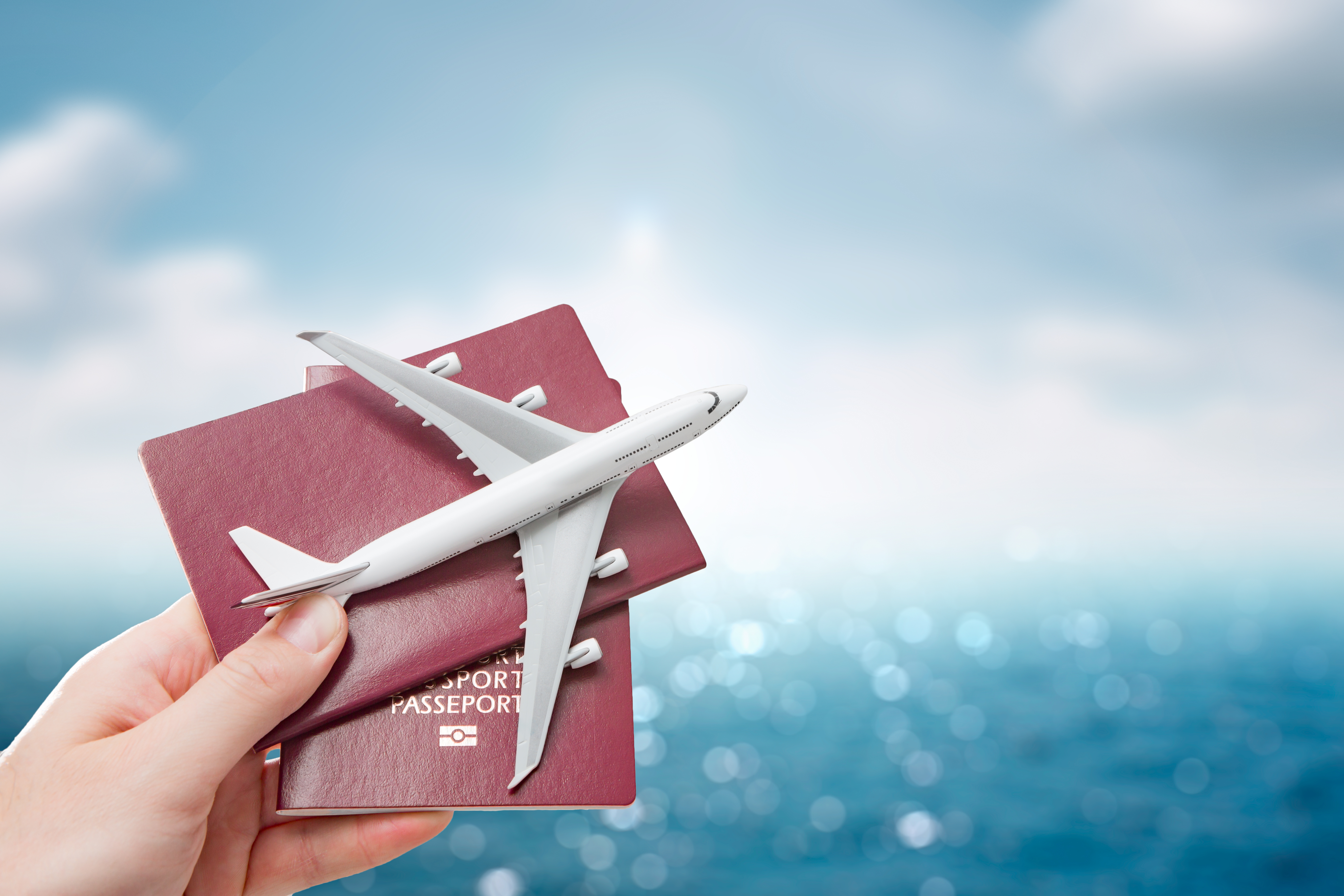 A person holding a toy airplane with a passport | Source: Shutterstock