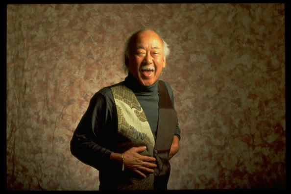 Actor Pat Morita laughing in front of nondescript backdrop | Photo: Getty Images
