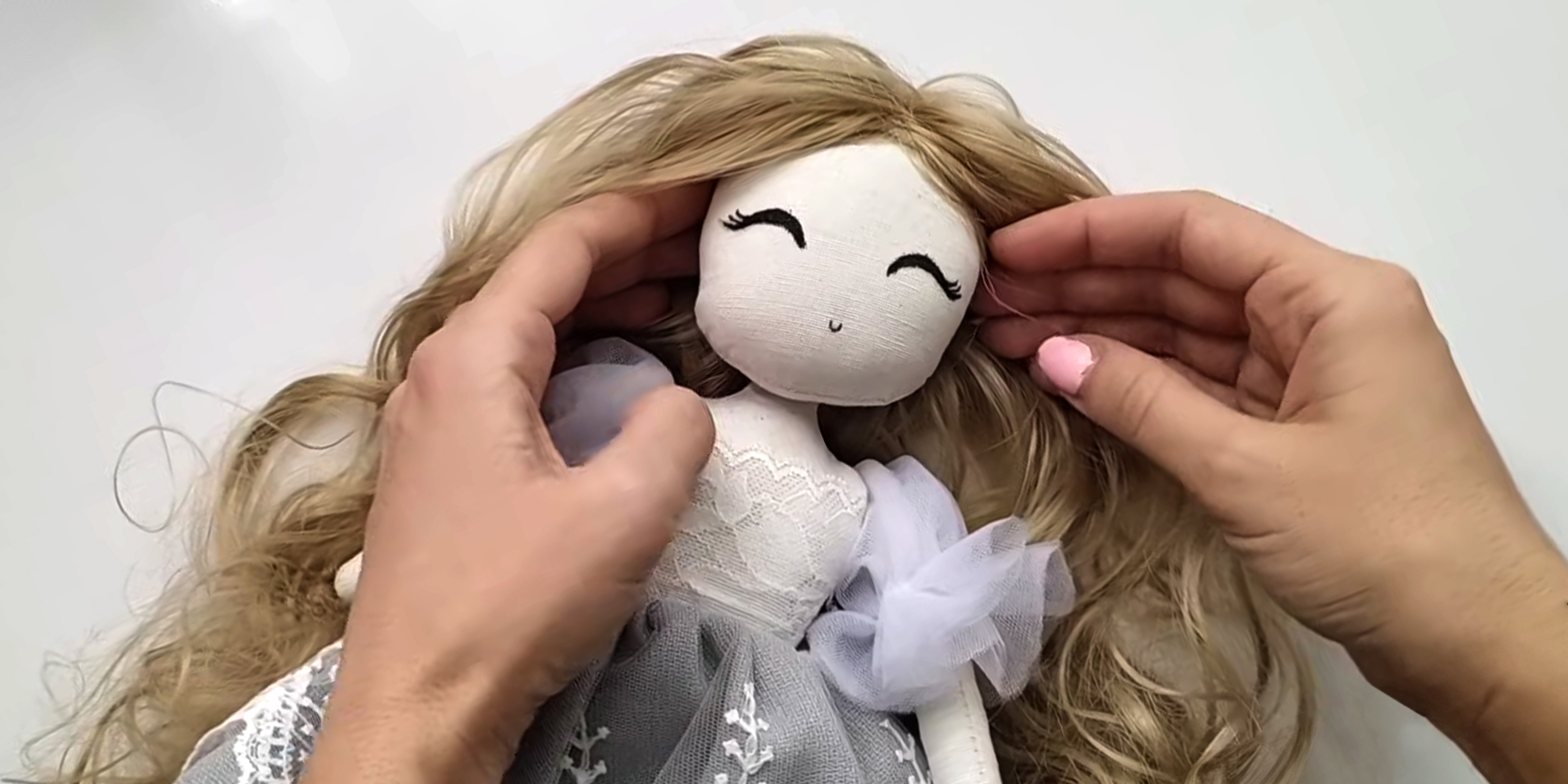 A person's hands and a doll | Source: YouTube/CraftyGirlShirin