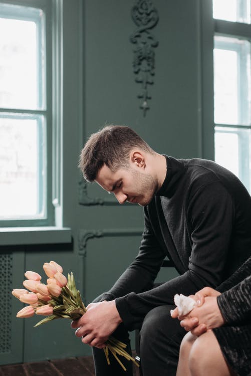 A photo of a grieving man at a funeral. | Photo: Pexels