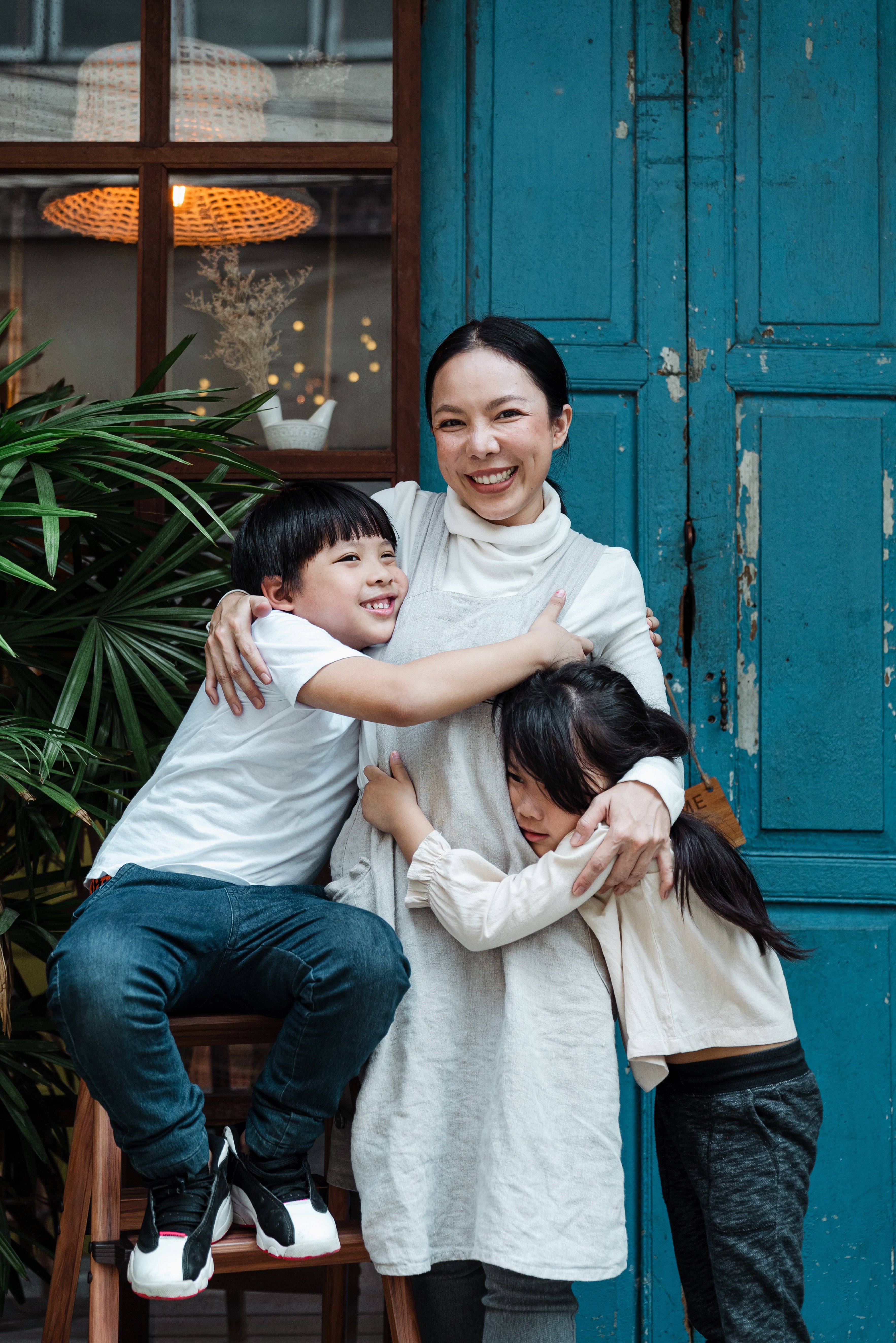 A mother hugging her two children. Pexels/ Ketut Subiyanto