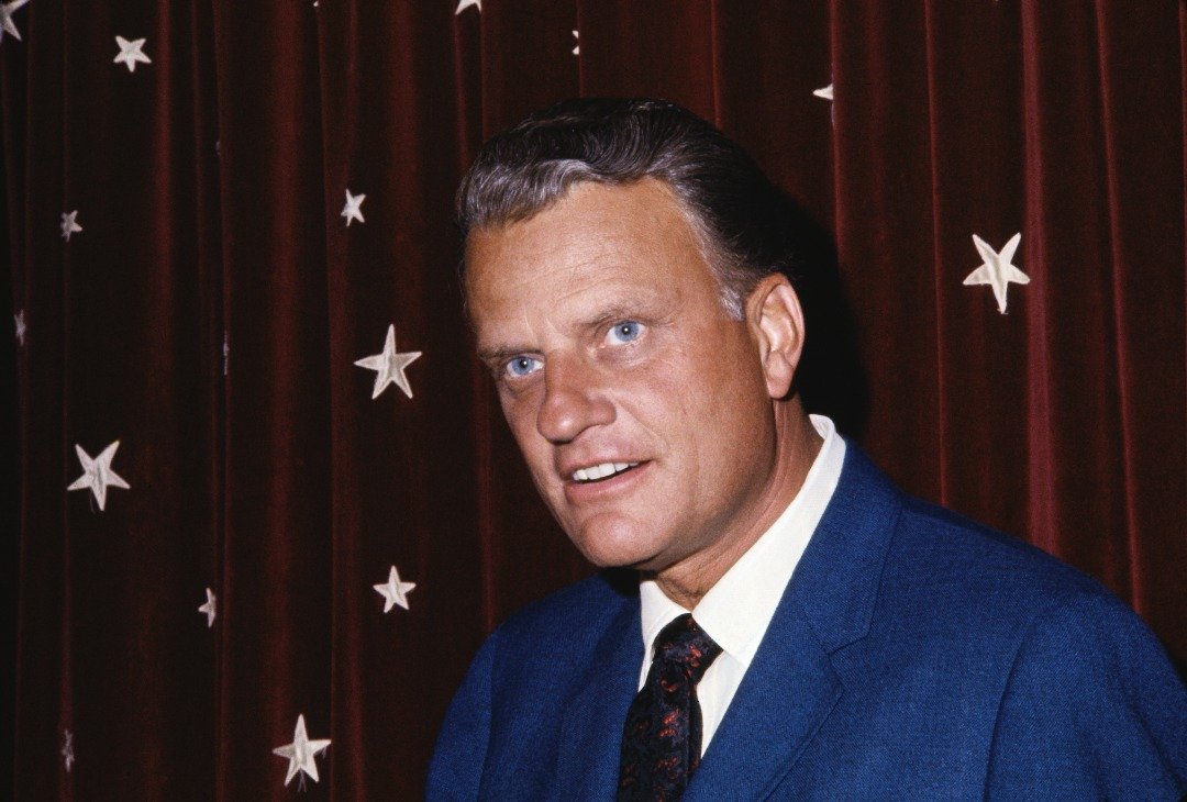 Close-up photo shows evangelist Billy Graham in front of an American flag. | Source: Getty Images