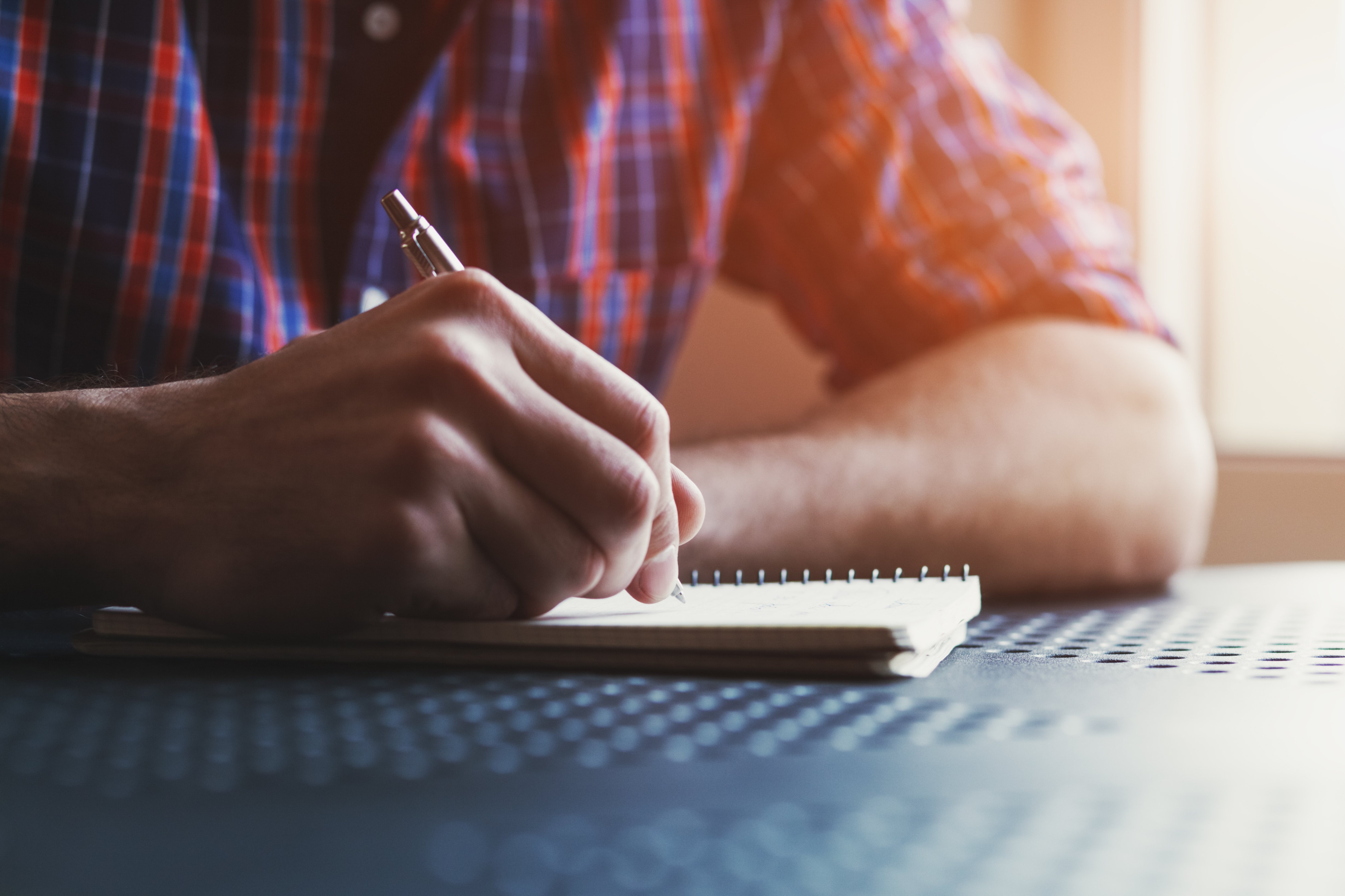 Hombre escribiendo nota. | Foto: Shutterstock