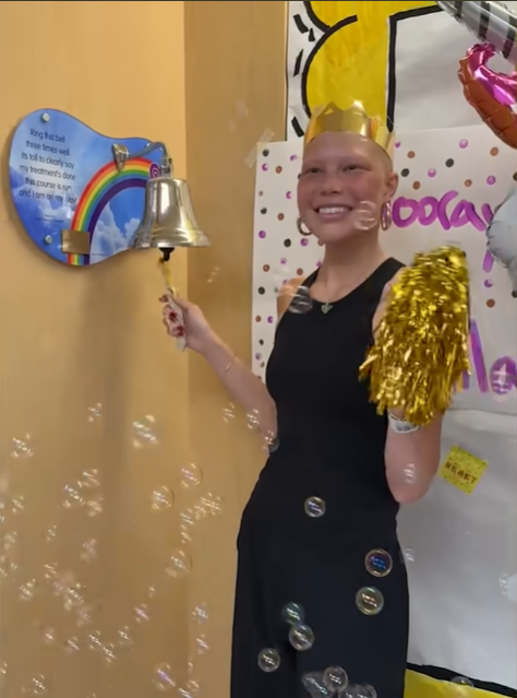 Isabella Strahan happily rings the bell before her family and the nursing staff, signaling the end of her chemotherapy, June 2024. | Source: YouTube/IsabellaStrahan