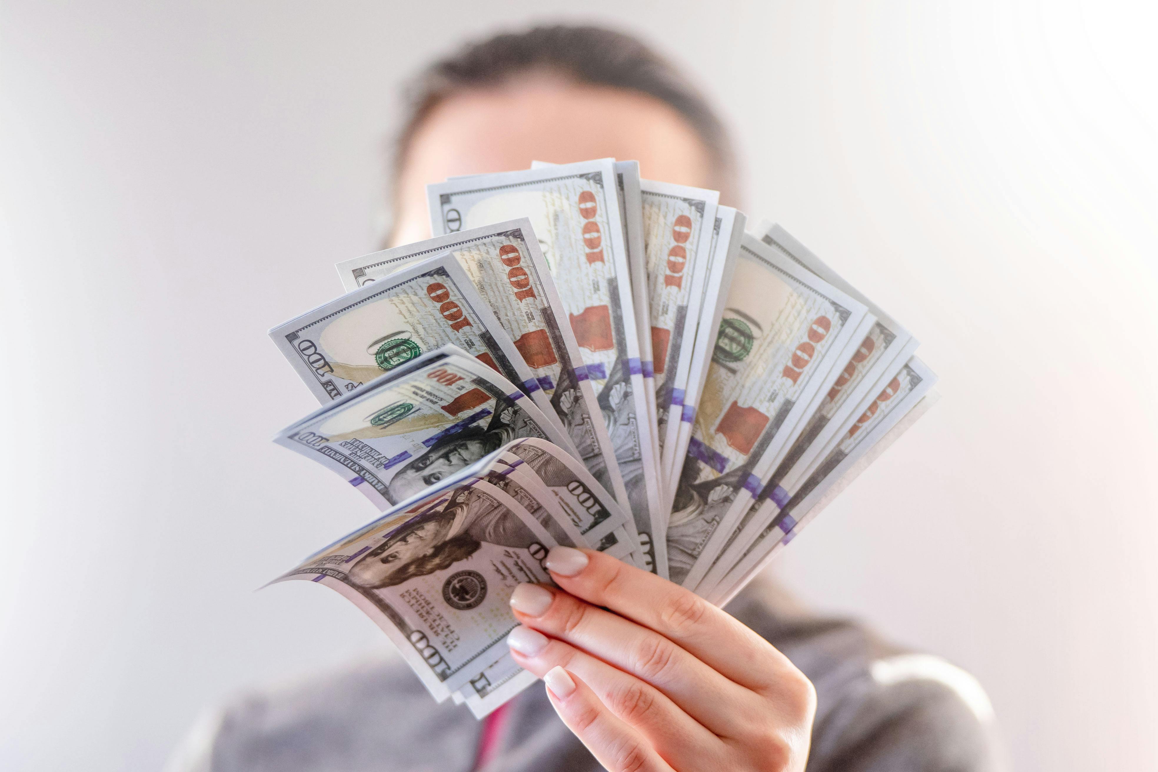 Woman holding a wad of money | Source: Pexels