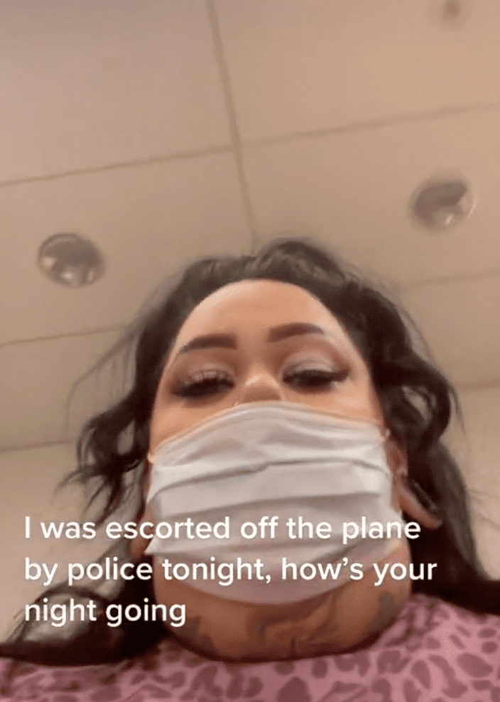 Woman records footage as she is escorted off of a plane by police officers | Photo: TikTok/fattrophywife