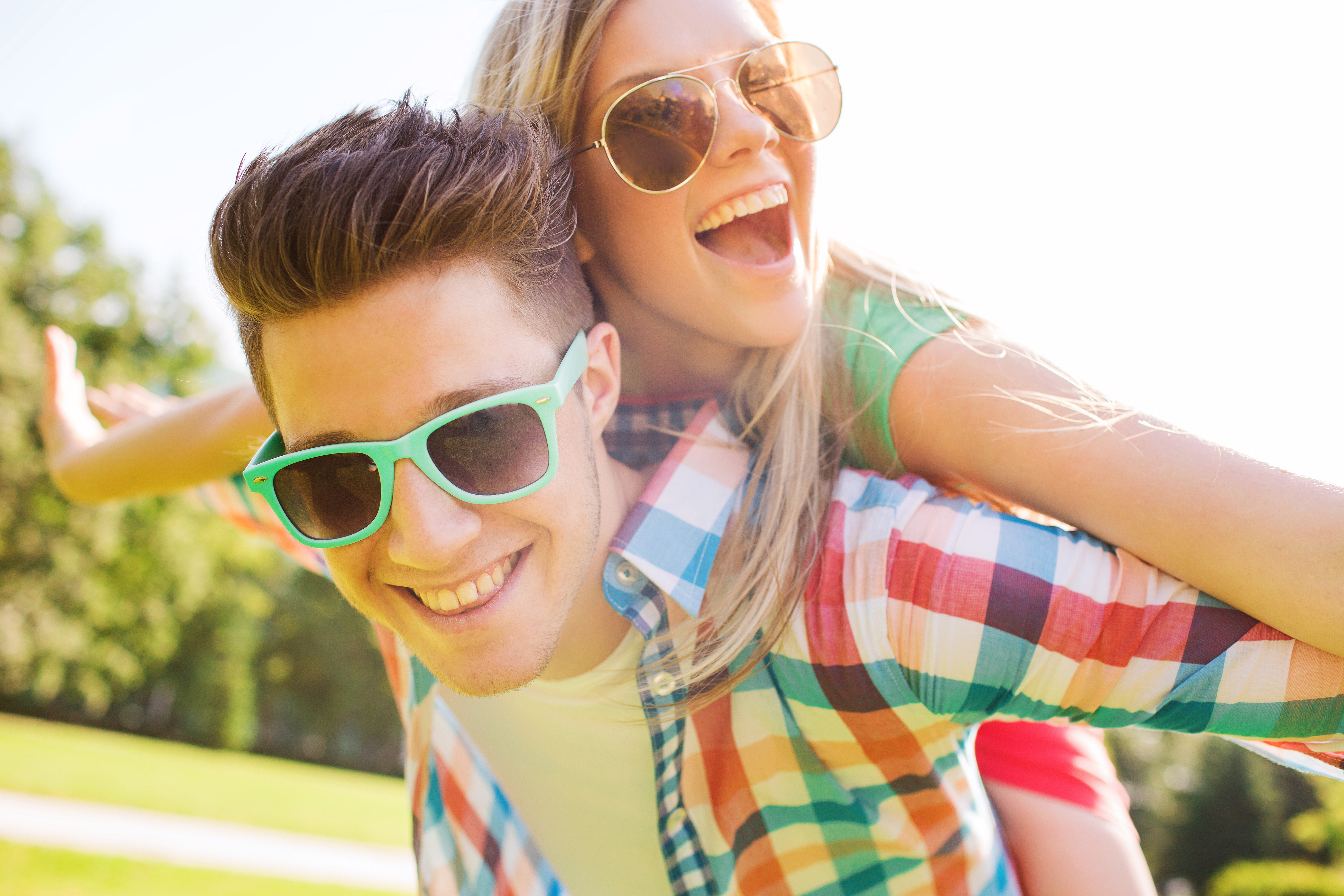 A happy young couple with sunglasses on smiling in the sun | Source: Shutterstock