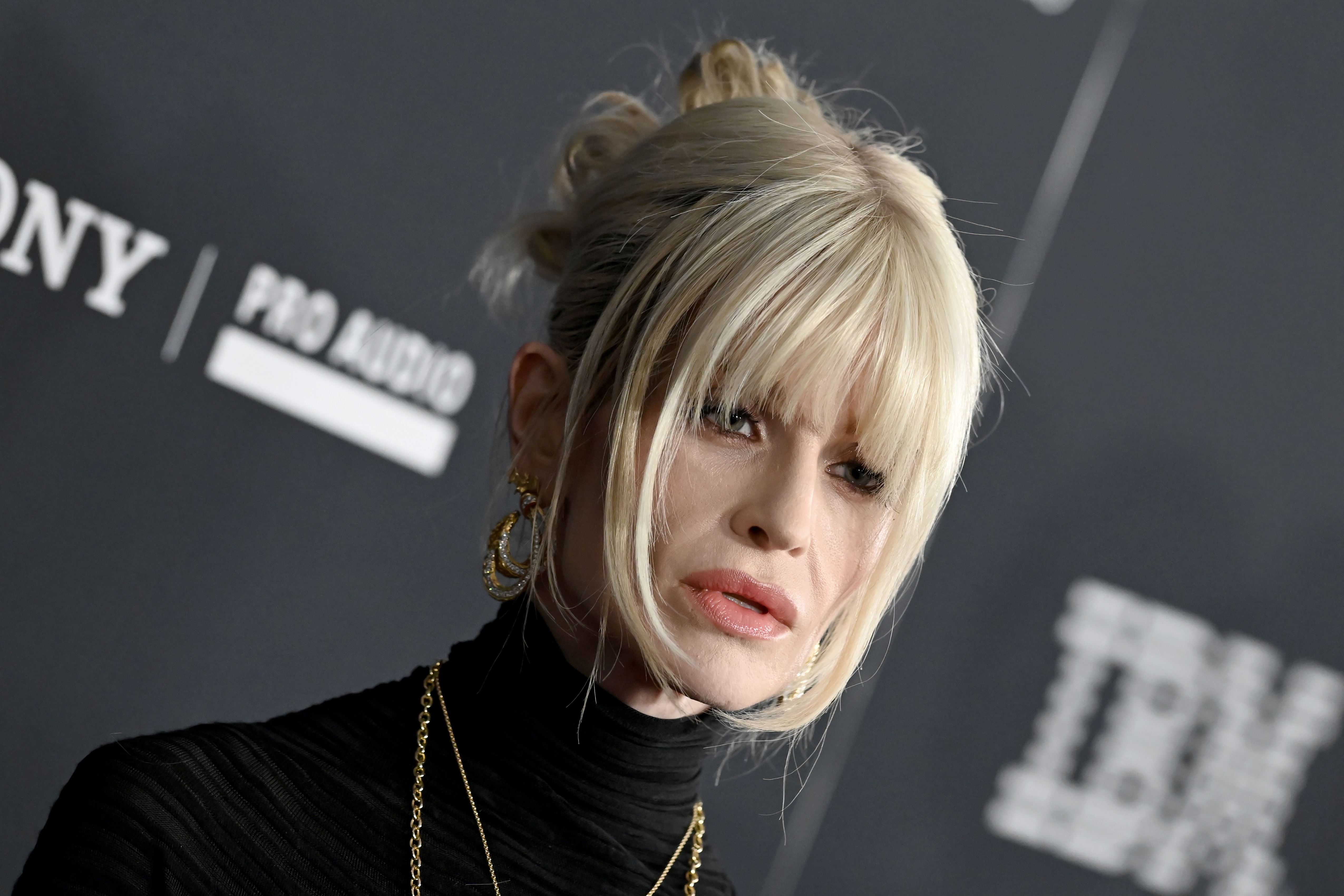 Kelly Osbourne poses on the red carpet at the 68th Grammy Awards pre-Grammy gala at The Beverly Hilton in Beverly Hills on January 31, 2026. Wearing a fitted black look with layered gold jewellery, Kelly is photographed in profile as she pauses for cameras during the high-profile industry event held ahead of the Grammy Awards.