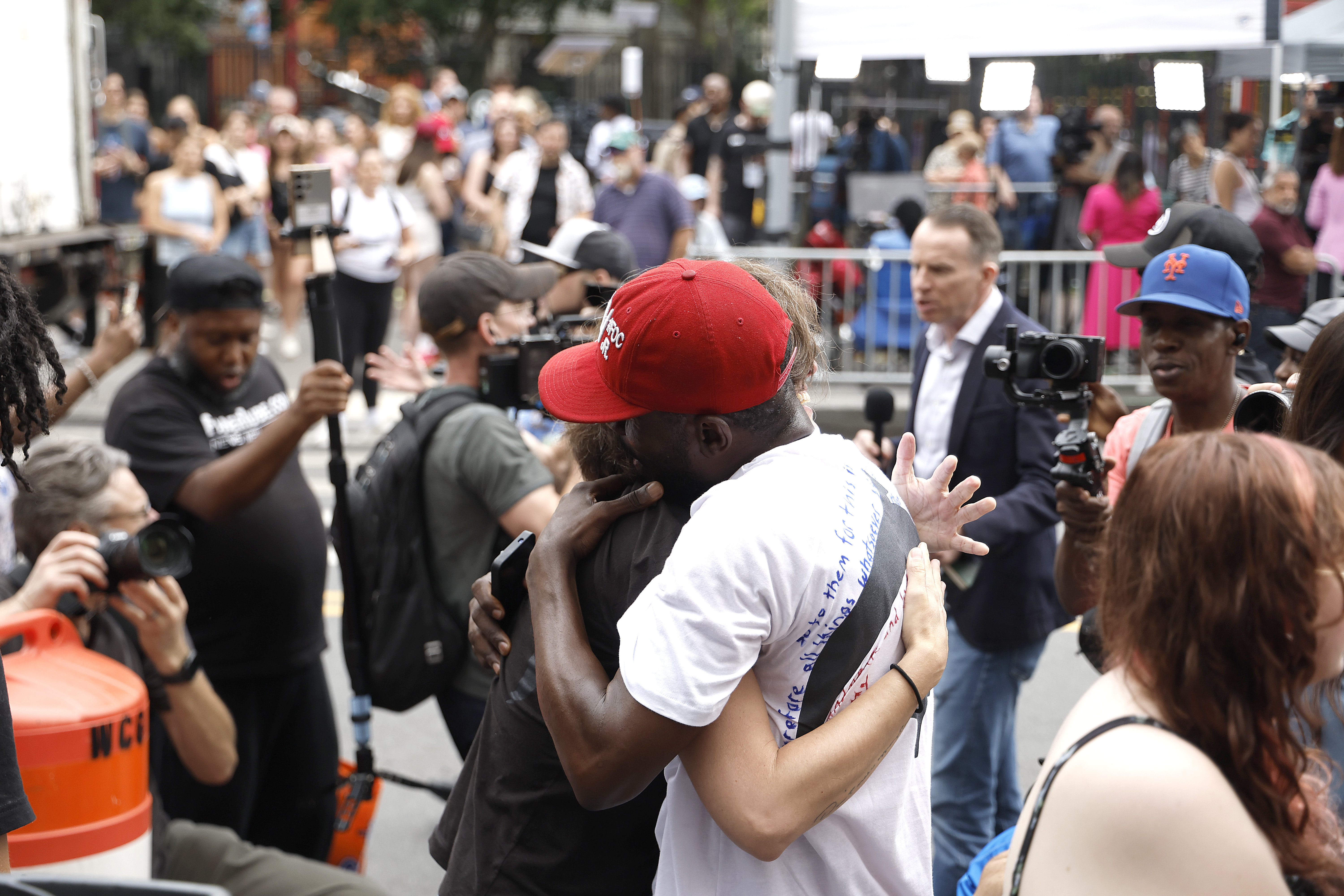 Supporters embrace outside Manhattan Federal Court after the jury’s partial verdict in Sean Combs’ trial. The crowd reacts with hugs, cameras rolling, capturing the emotionally charged atmosphere.
