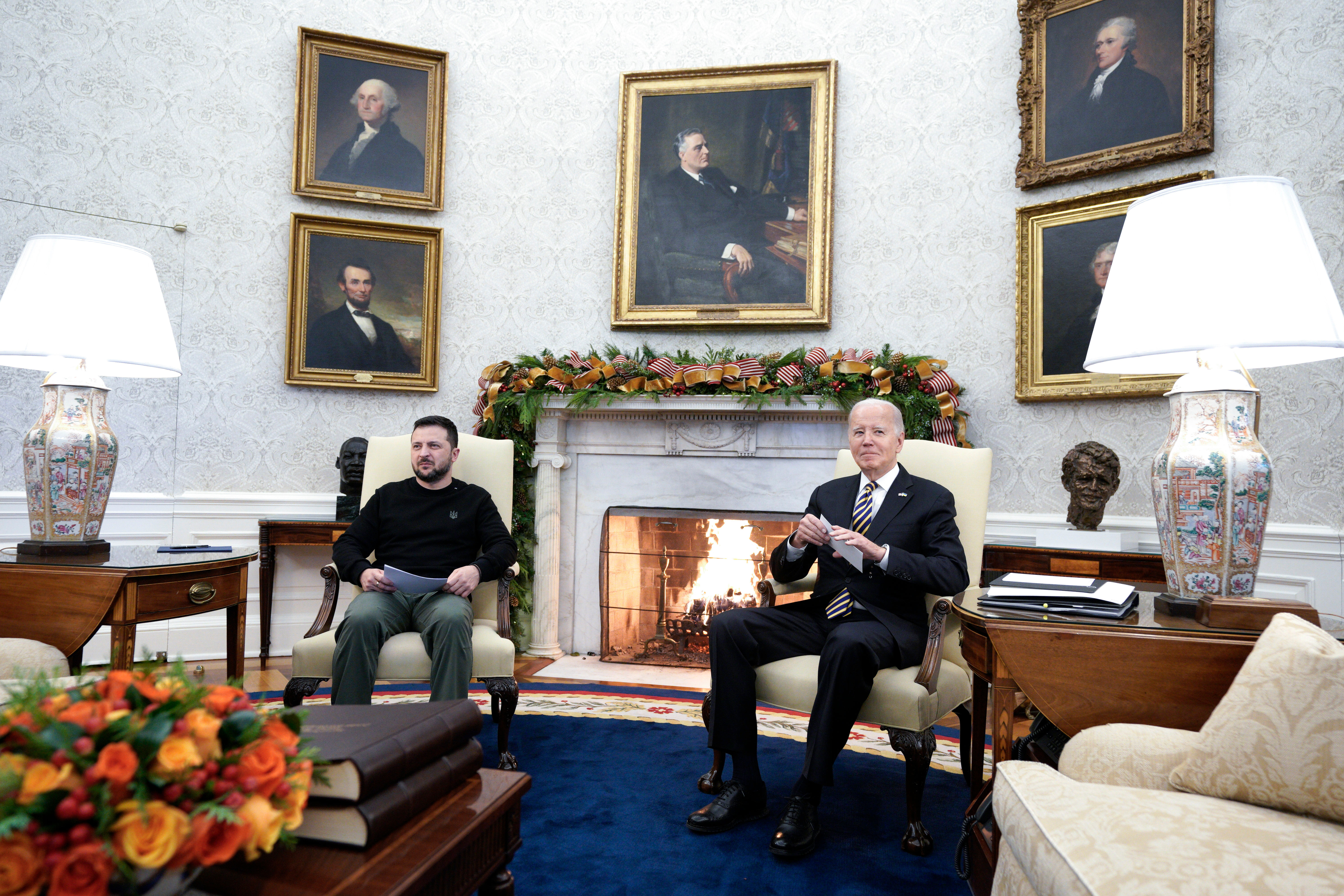 The Oval Office, featuring a lit fireplace and portraits of past presidents, sets the scene for a meeting on December 12, 2023, between Joe Biden and Ukraine's Volodymyr Zelenskiy.