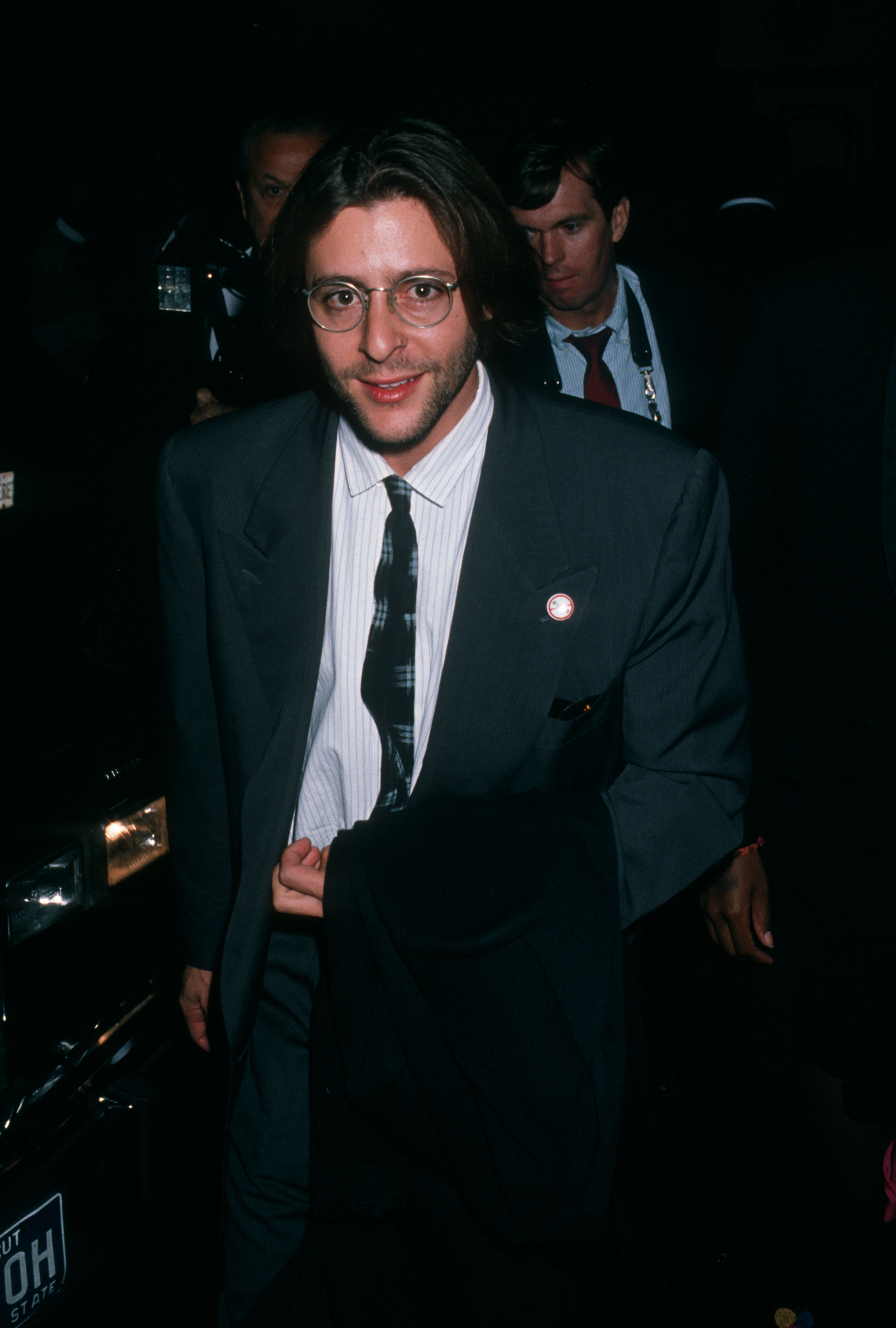 Wearing round-frame glasses and a dark suit, the actor arrives at the Ziegfeld Theater in New York City for the premiere of "Old Gringo." | Source: Getty Images