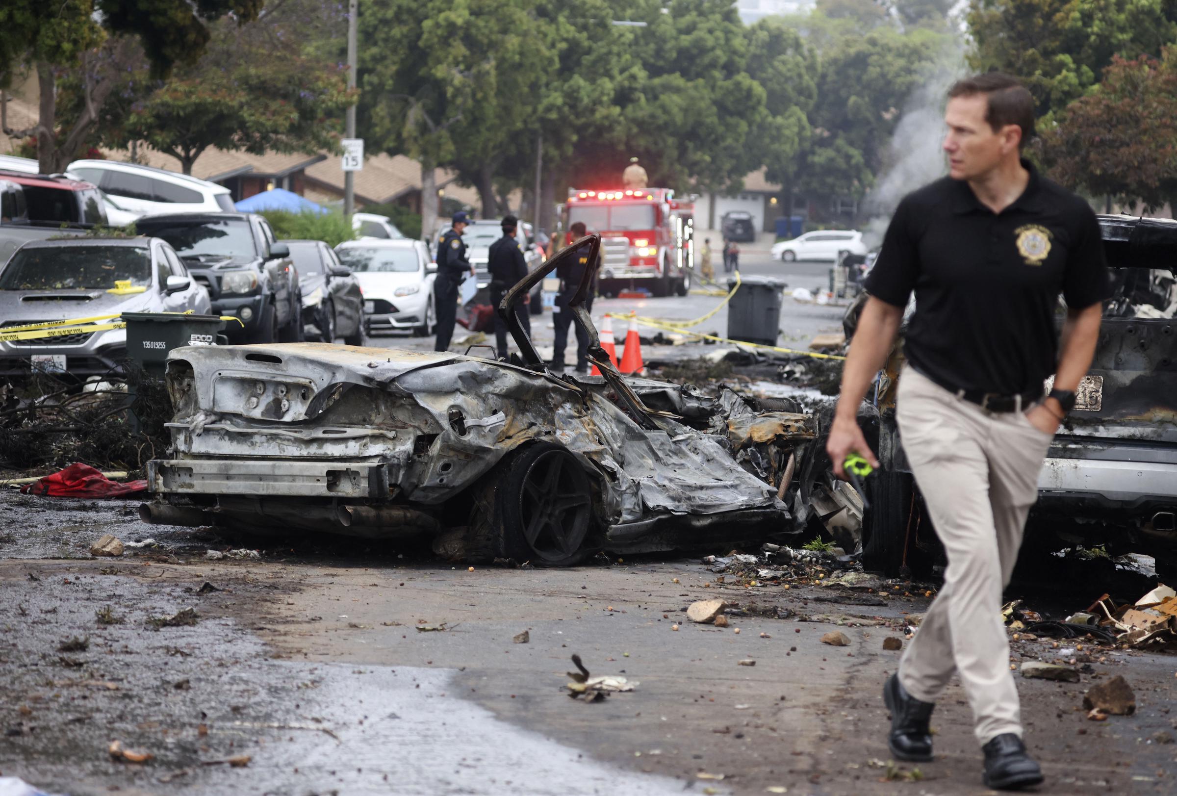 Investigators walk through the wreckage after the Cessna 550 crashed near Montgomery-Gibbs Executive Airport in San Diego on May 22, 2025 | Source: Getty Images