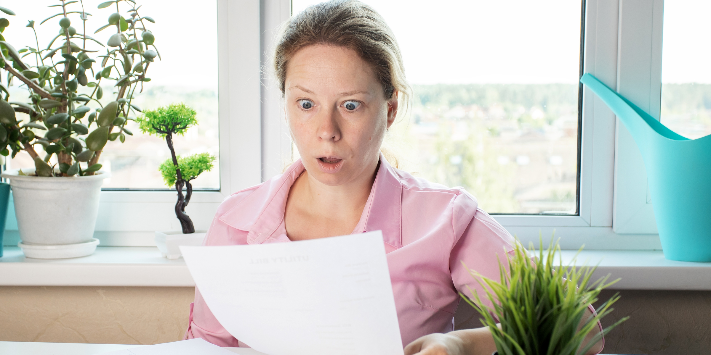 A shocked woman reading something on a paper | Source: Shutterstock