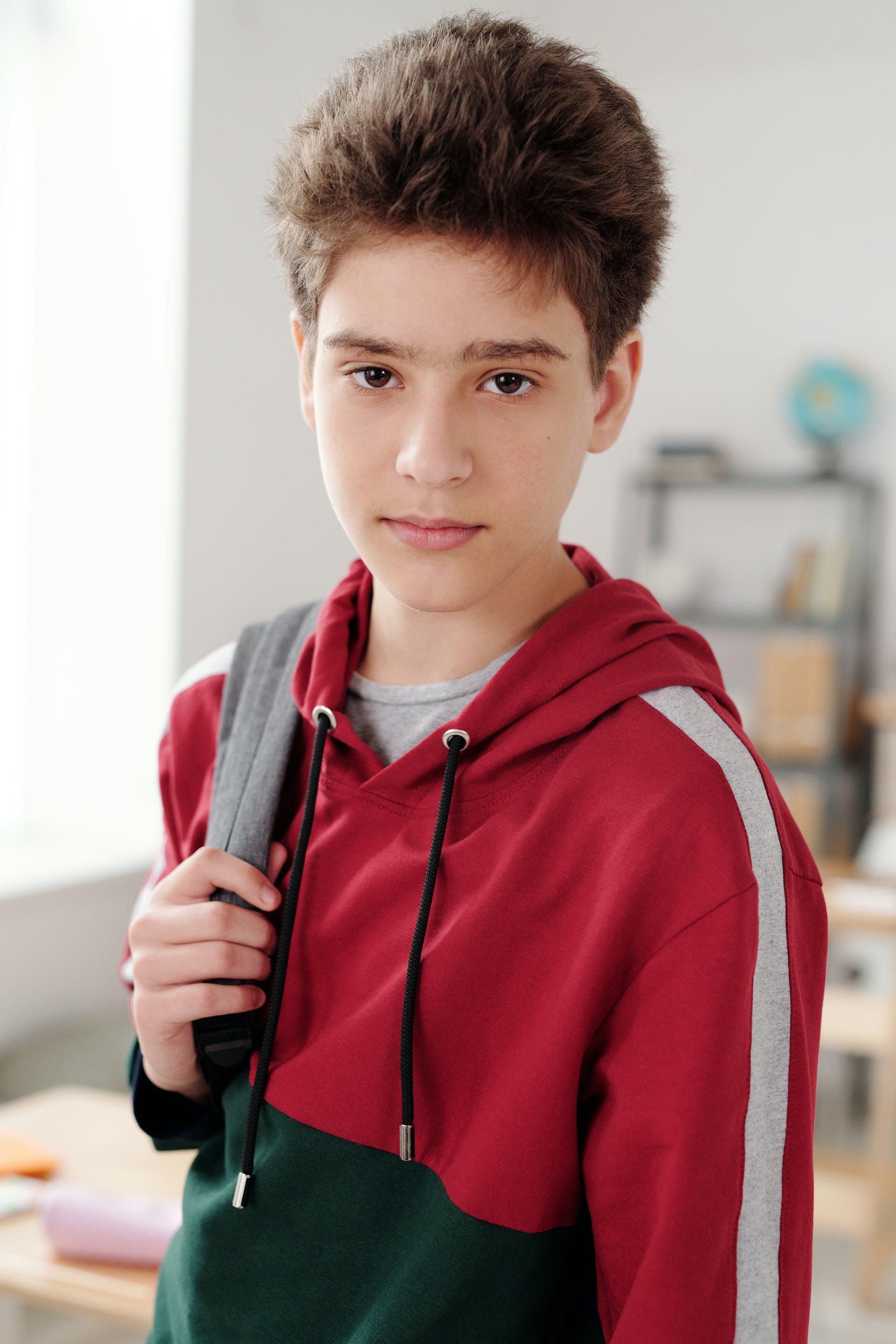 A young boy with a bag on his shoulder | Source: Pexels