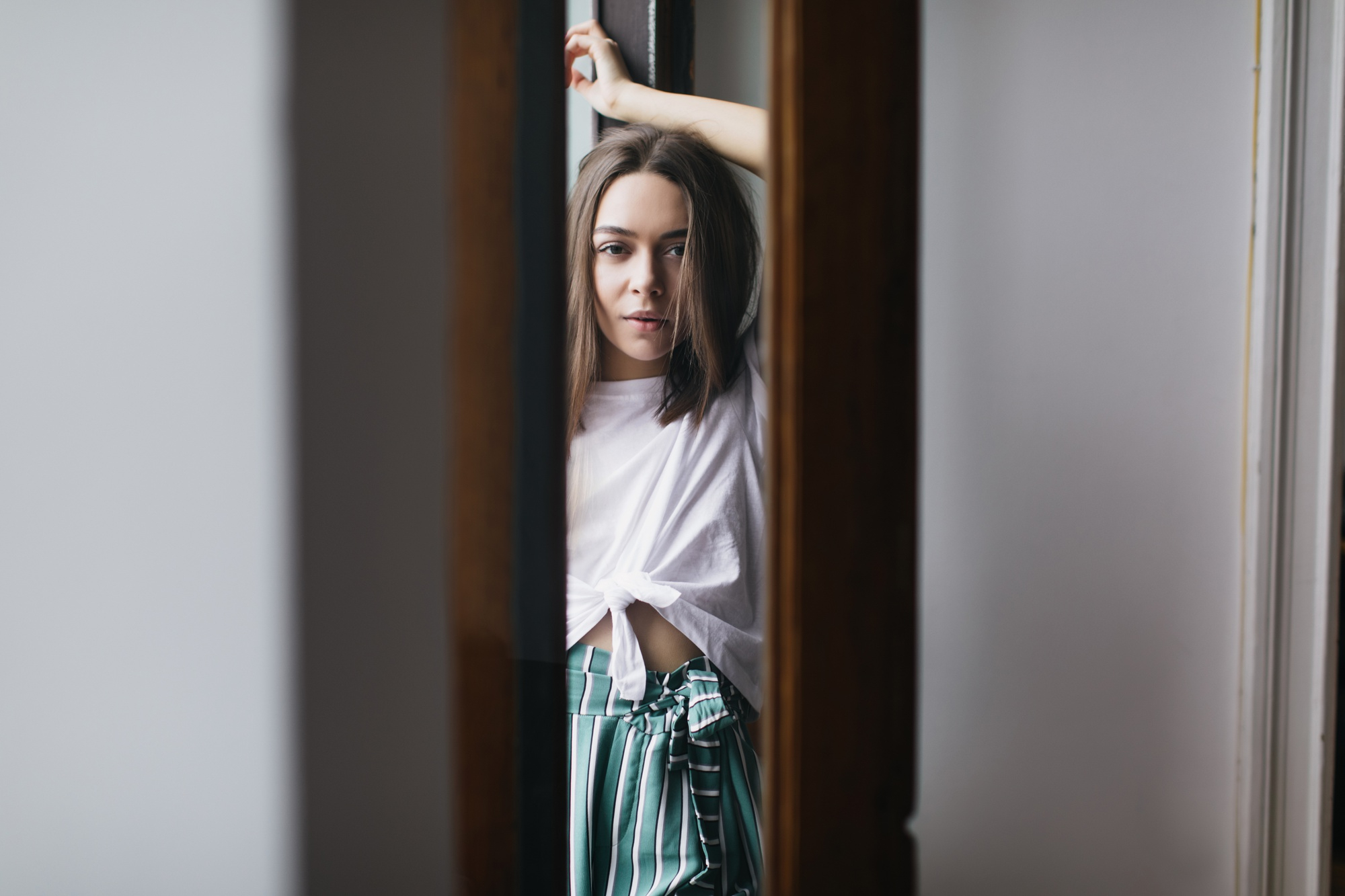 A woman seen through the crack of an open door | Source: Freepik