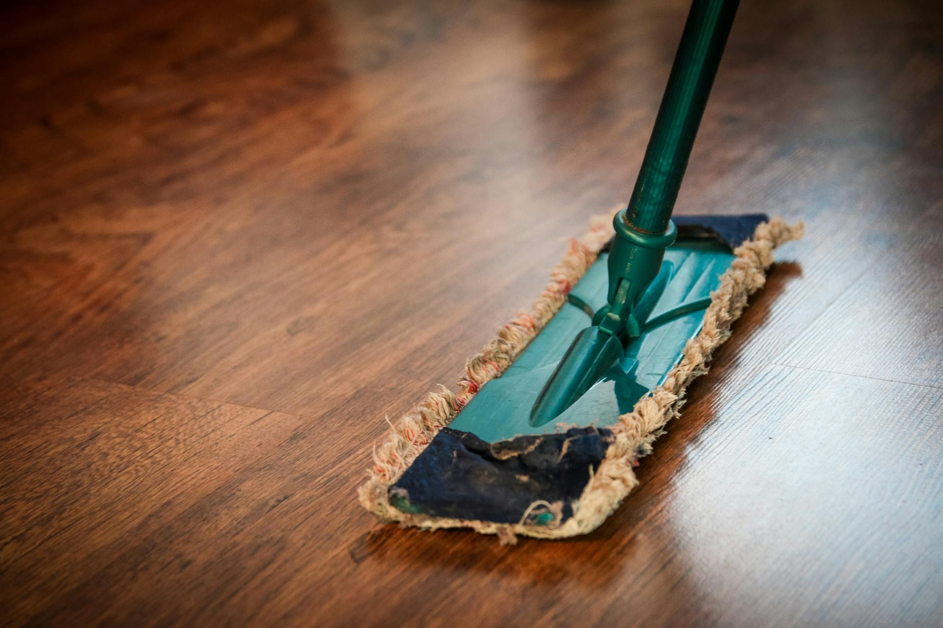 A mop on a brown wooden floor | Source: Pexels