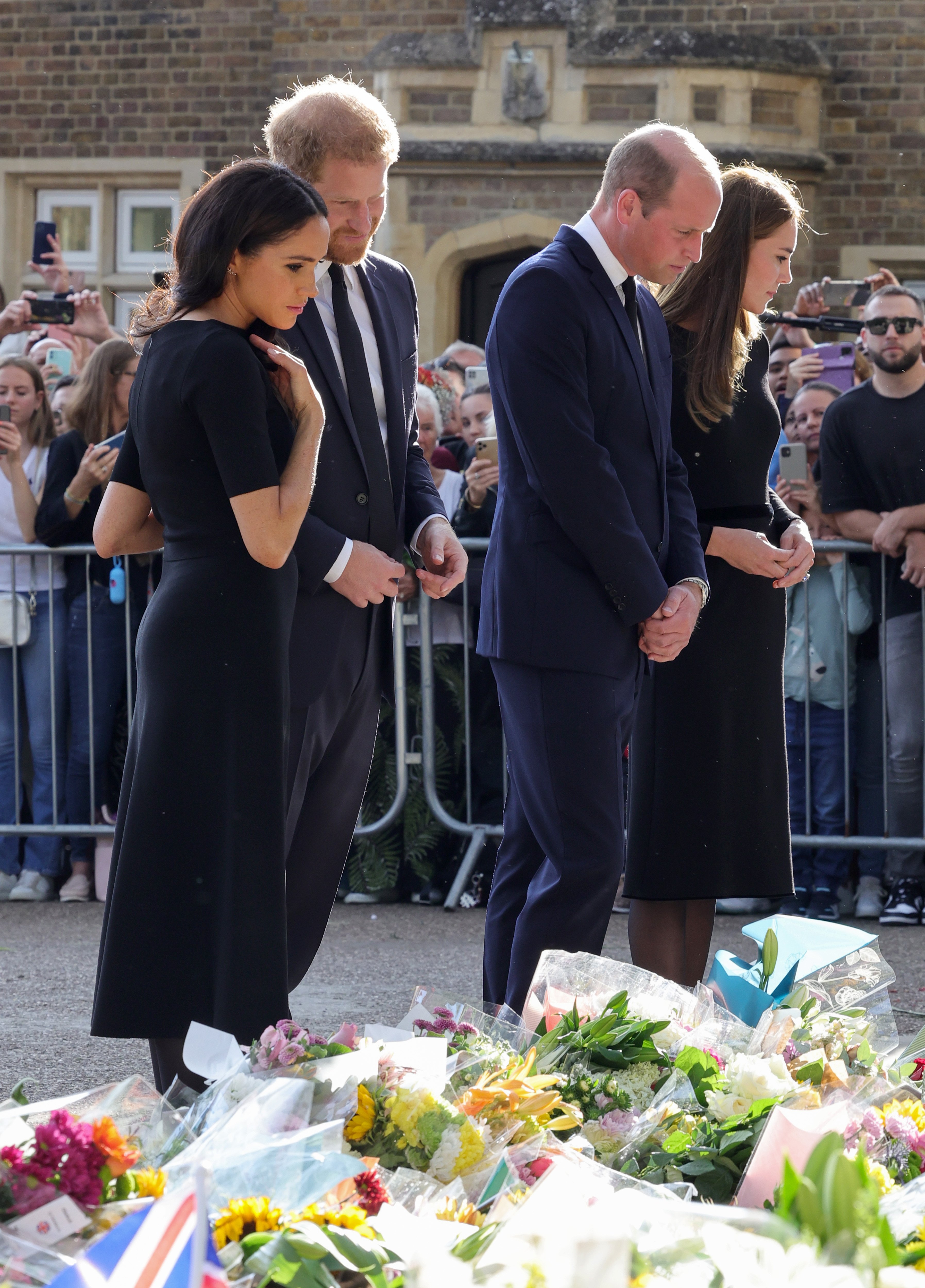 Meghan y Harry, duques de Sussex, William y Kate, príncipes de Gales, mirando los tributos florales en la caminata larga en el castillo de Windsor el 10 de septiembre de 2022 en Windsor, Inglaterra | Foto: Getty Images