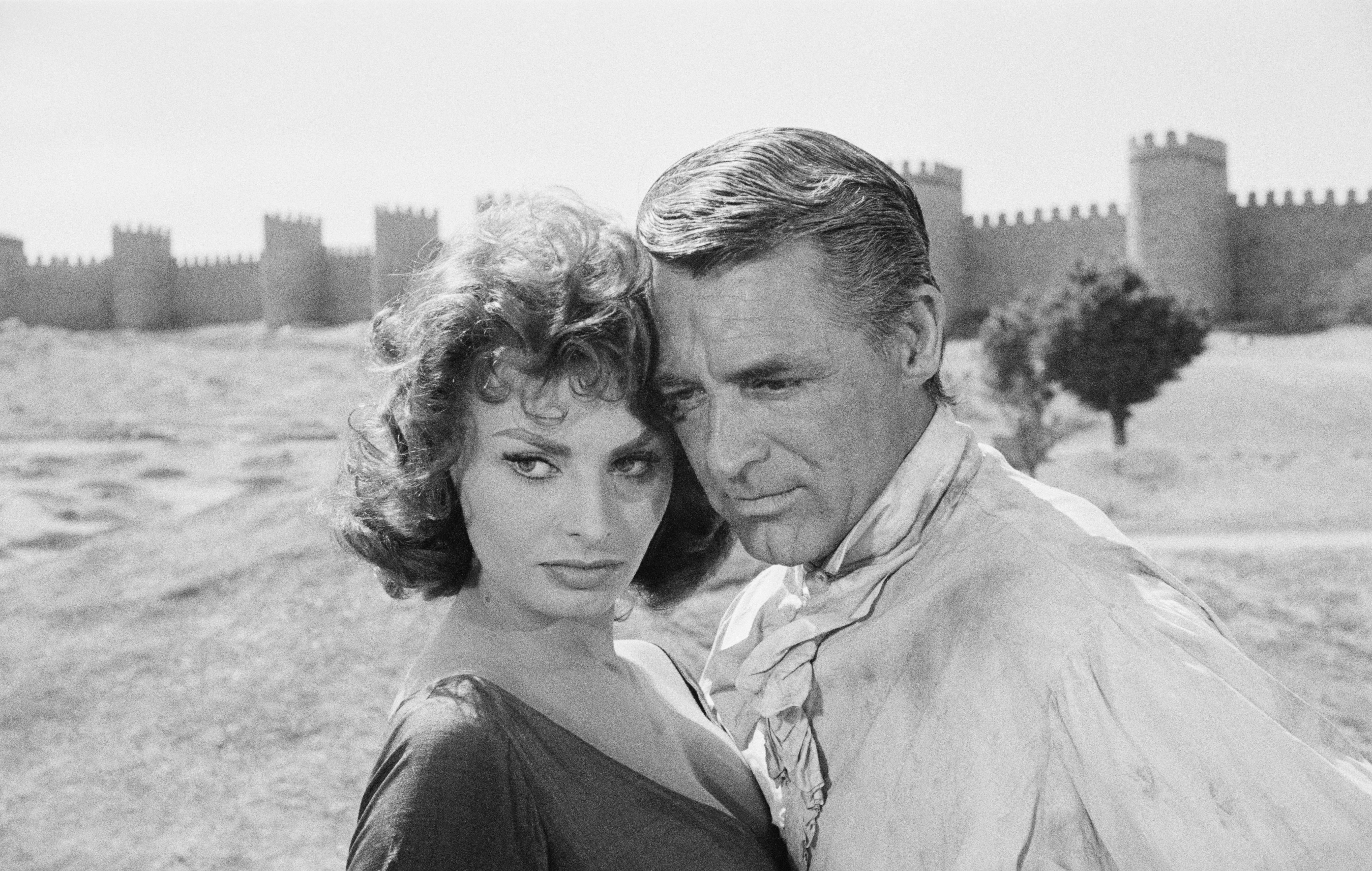 Cary Grant und Sophia Loren vor den Mauern von Avila, Spanien, während der Dreharbeiten zu "The Pride and the Passion“. | Quelle: Getty Images