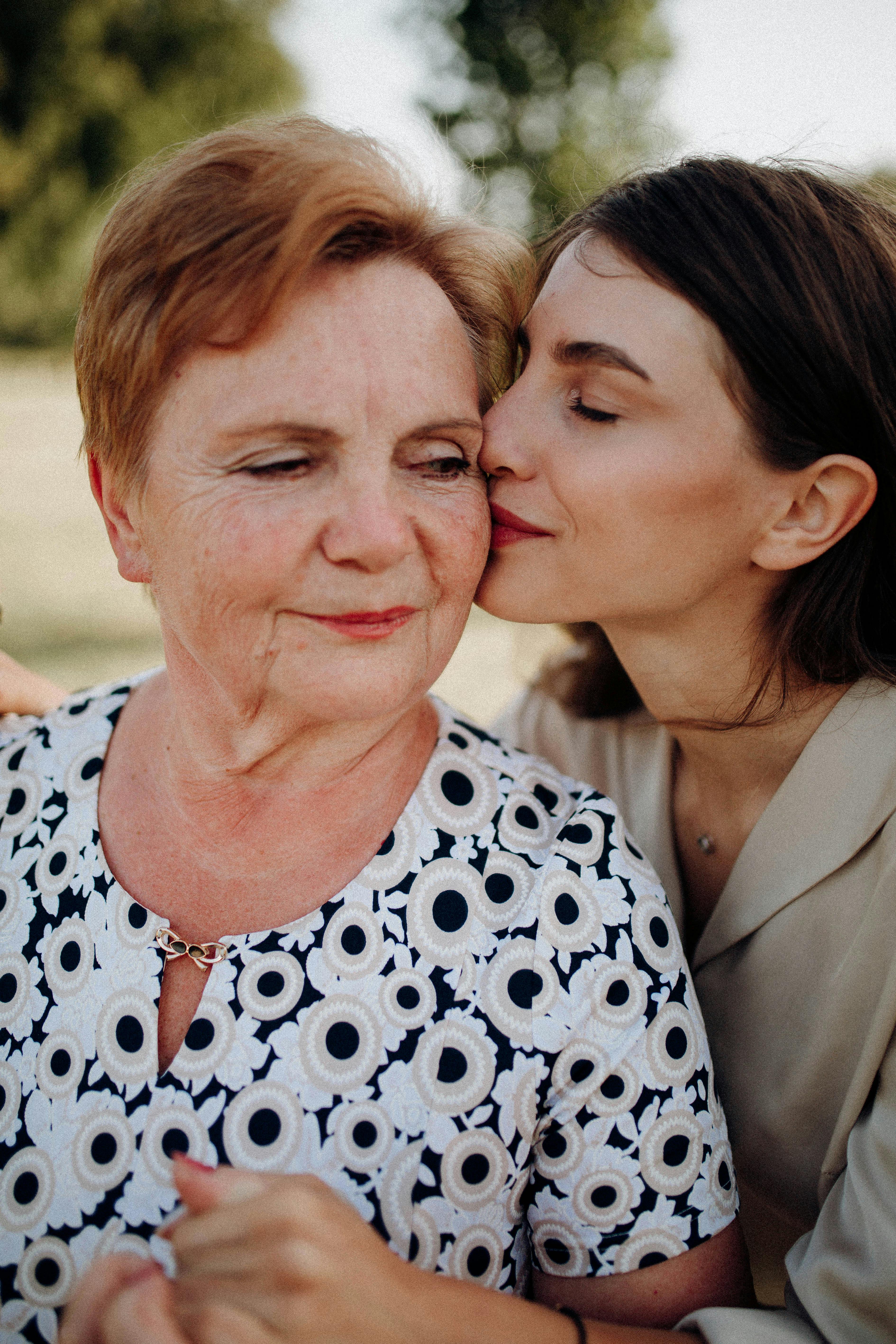 A young woman kissing an older woman on the cheek | Source: Pexels