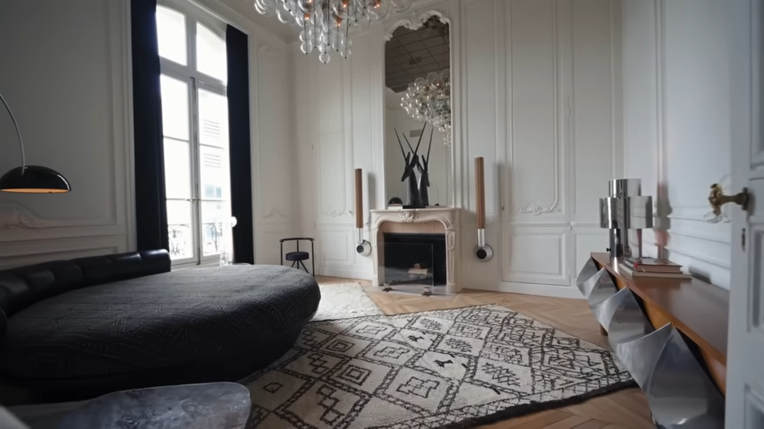 The stylish guest bedroom is styled with a unique round black bed, a geometric Moroccan rug, and a modern wood-and-metal console. | Source: YouTube/@Archdigest