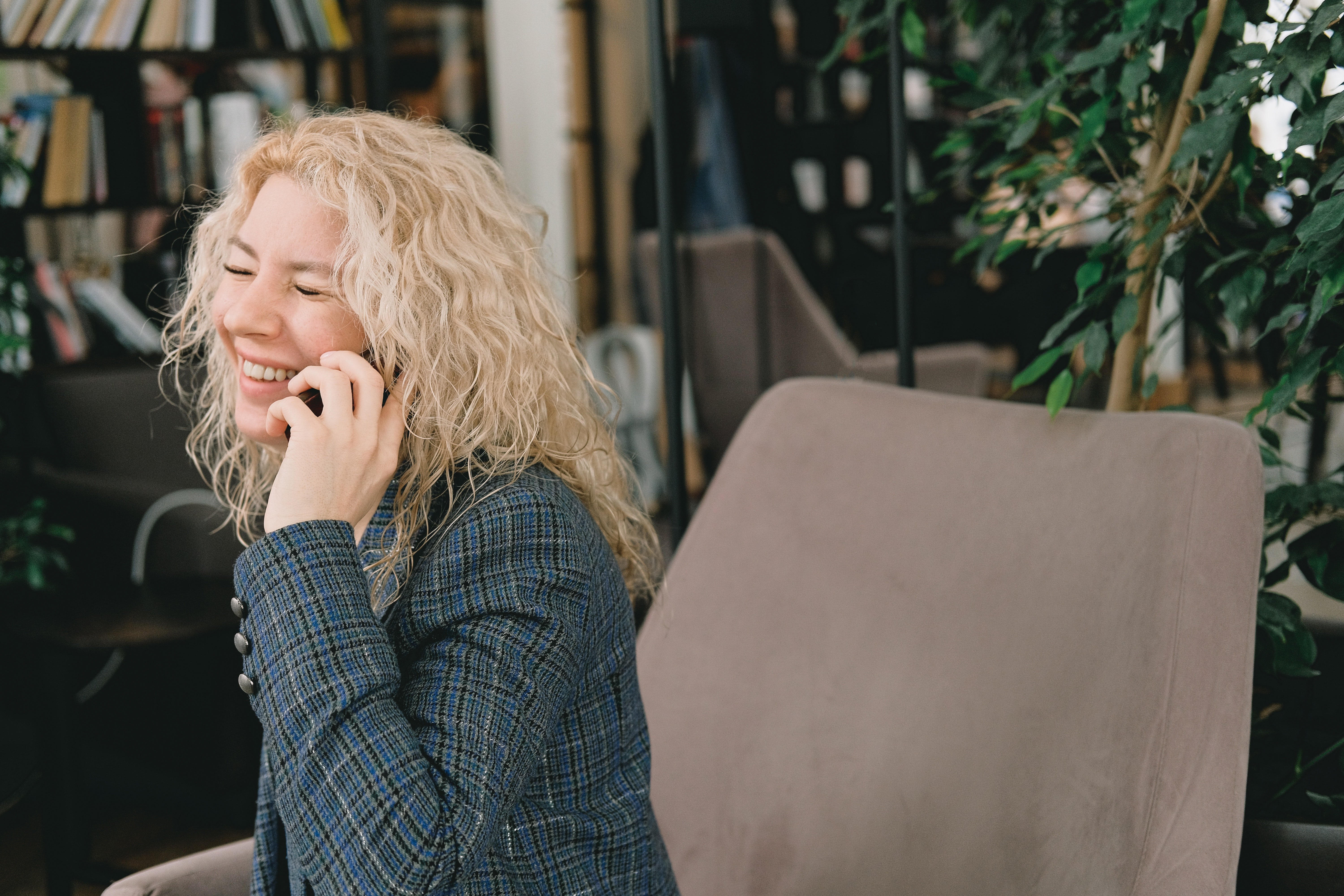 Una mujer sonríe feliz mientras habla por teléfono. | Foto: Pexels