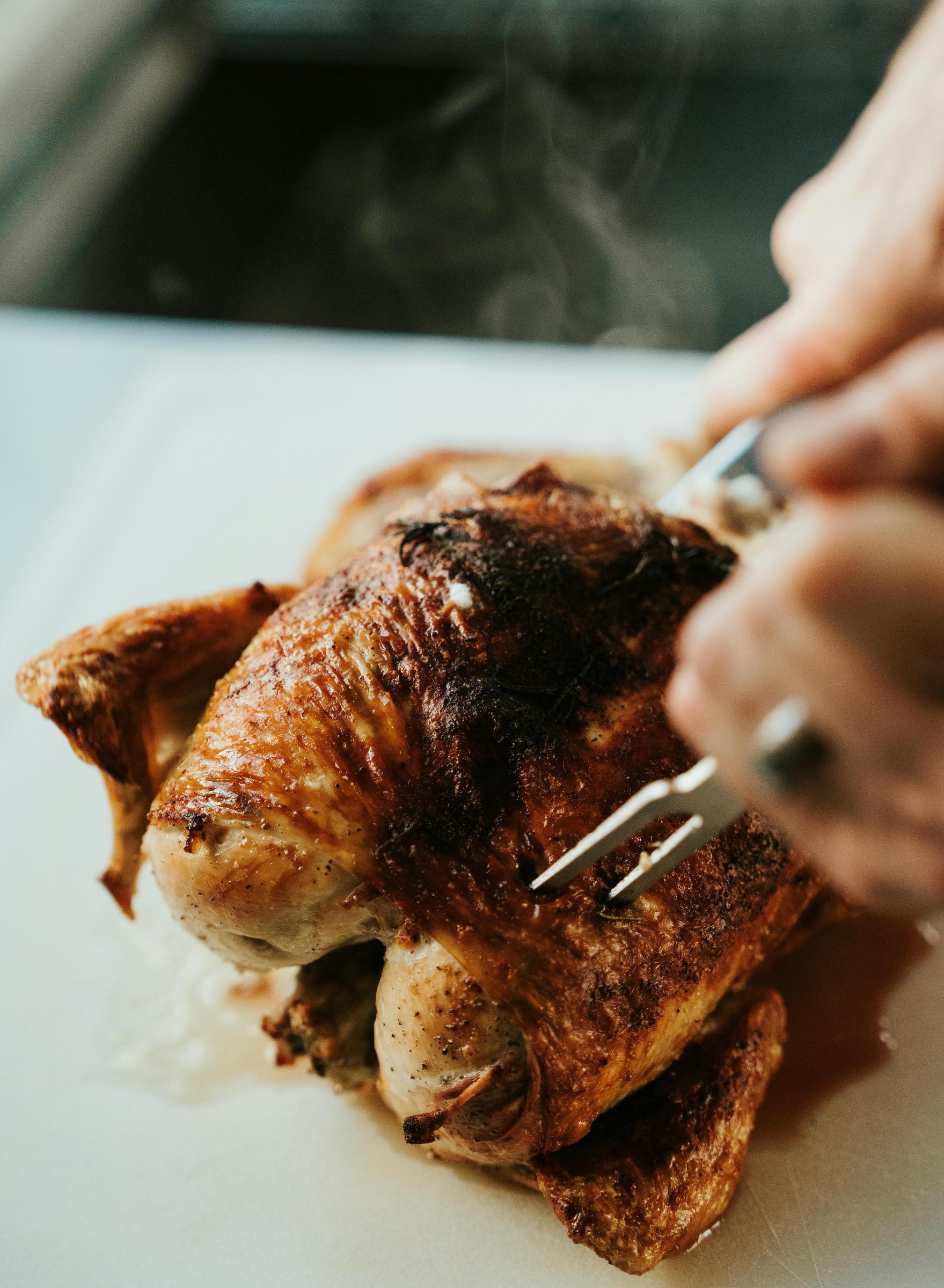 A piece of roast chicken getting cut | Source: Pexels