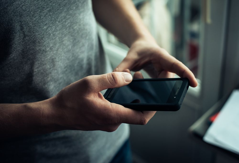 A man looking at his phone. | Source: Shutterstock