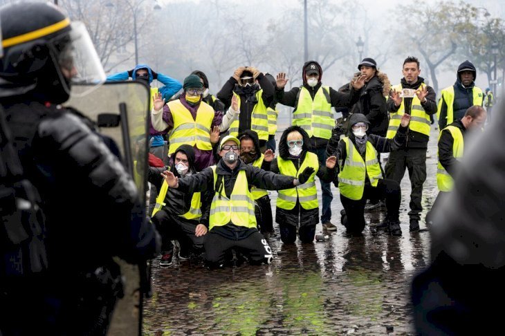 Des gilets jaunes mettant à genoux devant les CRS. l Source: Getty Images Des gilets jaunes mettant à genoux devant les CRS. l Source: Getty Images