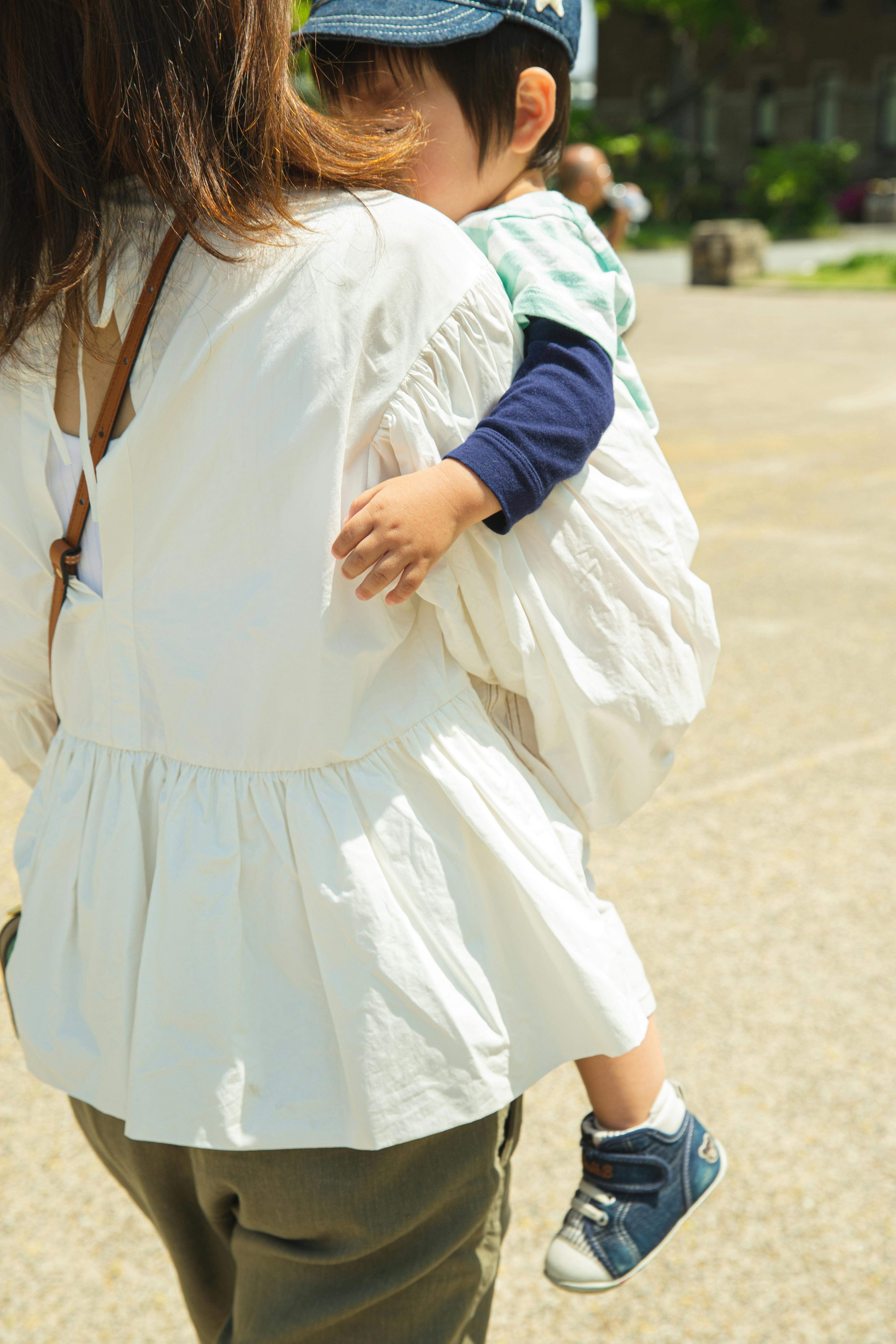 A woman holding a child in her arms | Source: Pexels